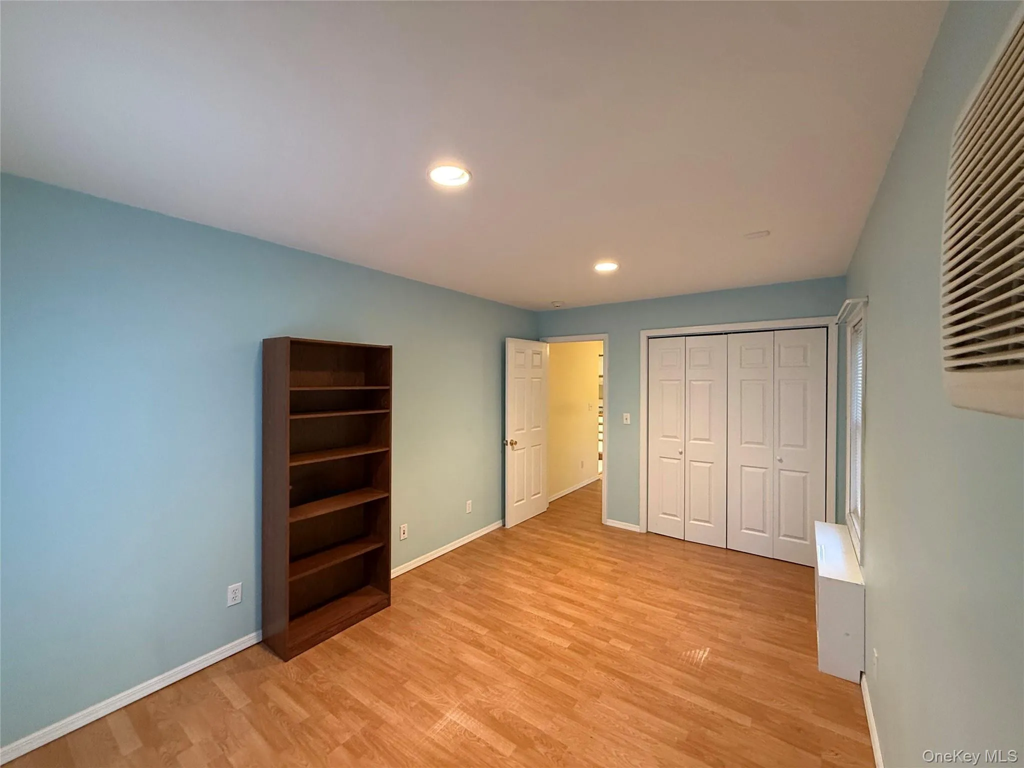 Unfurnished bedroom with light wood-style flooring, a closet, and recessed lighting Unfurnished bedroom with light wood-style flooring, a closet, and recessed lighting