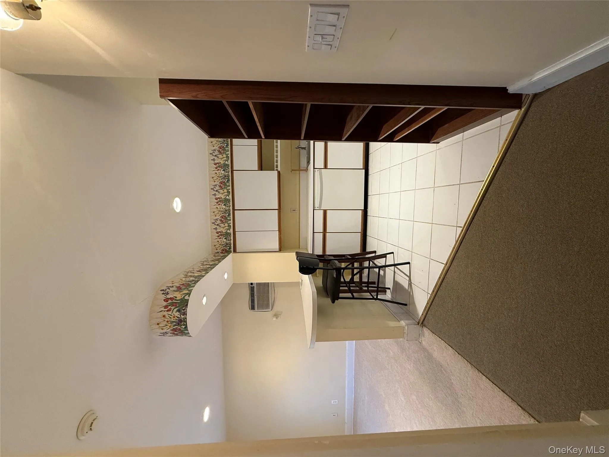Kitchen with light colored carpet, white cabinets, light countertops, a peninsula, and light tile patterned flooring Kitchen with light colored carpet, white cabinets, light countertops, a peninsula, and light tile patterned flooring