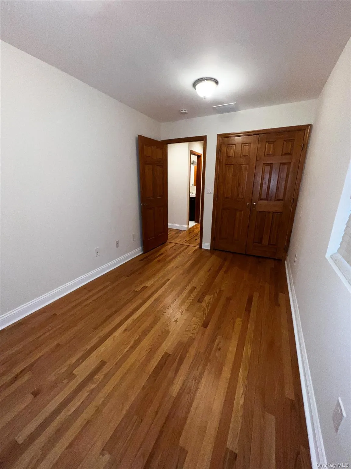 Unfurnished bedroom with wood finished floors and a closet Unfurnished bedroom with wood finished floors and a closet
