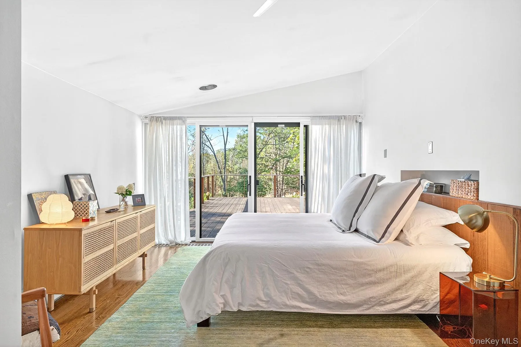 Main first floor bedroom with slider to deck. Main first floor bedroom with slider to deck.
