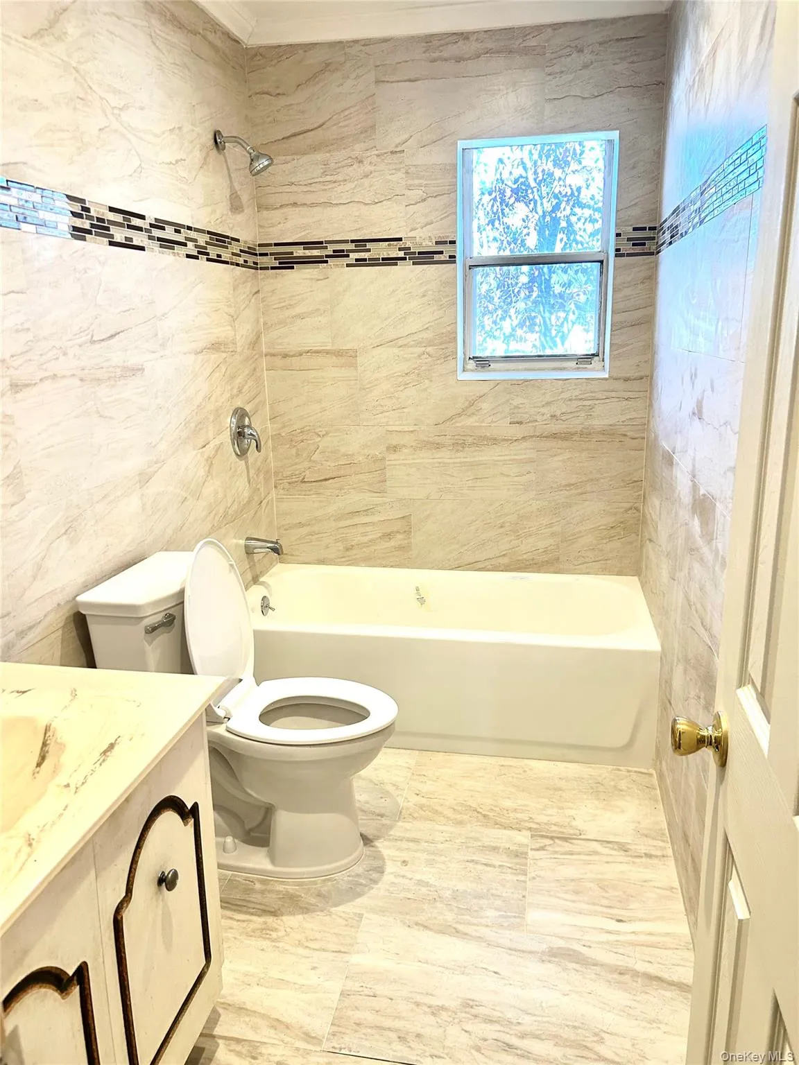 Full bath with vanity, shower / tub combination, and tile walls Full bath with vanity, shower / tub combination, and tile walls