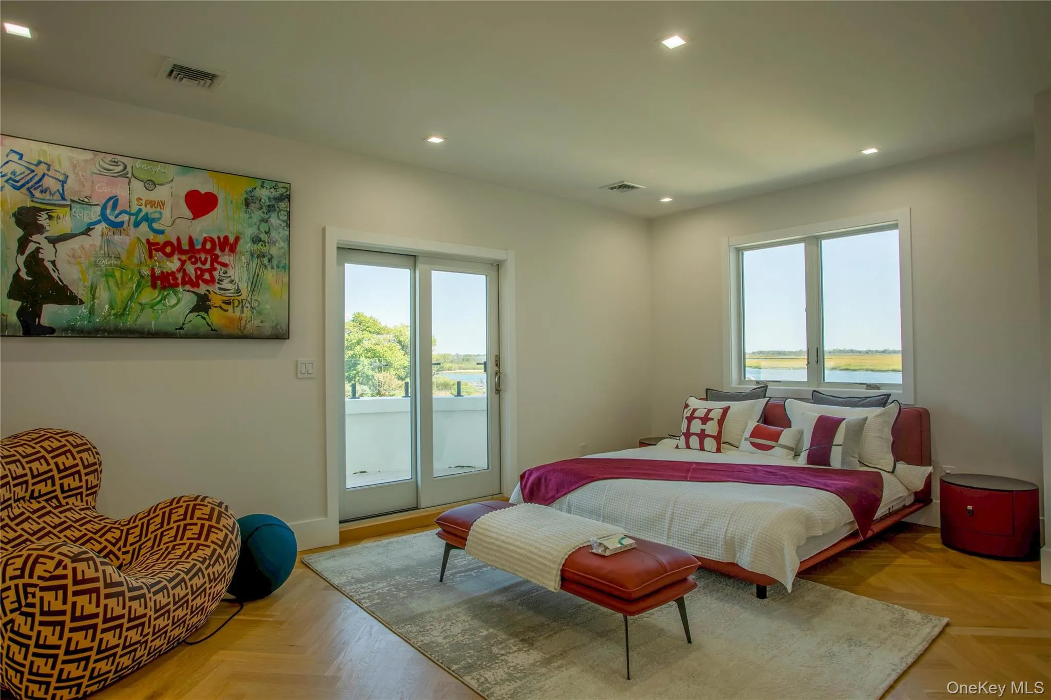 Bedroom featuring recessed lighting, access to exterior, and a water view Bedroom featuring recessed lighting, access to exterior, and a water view