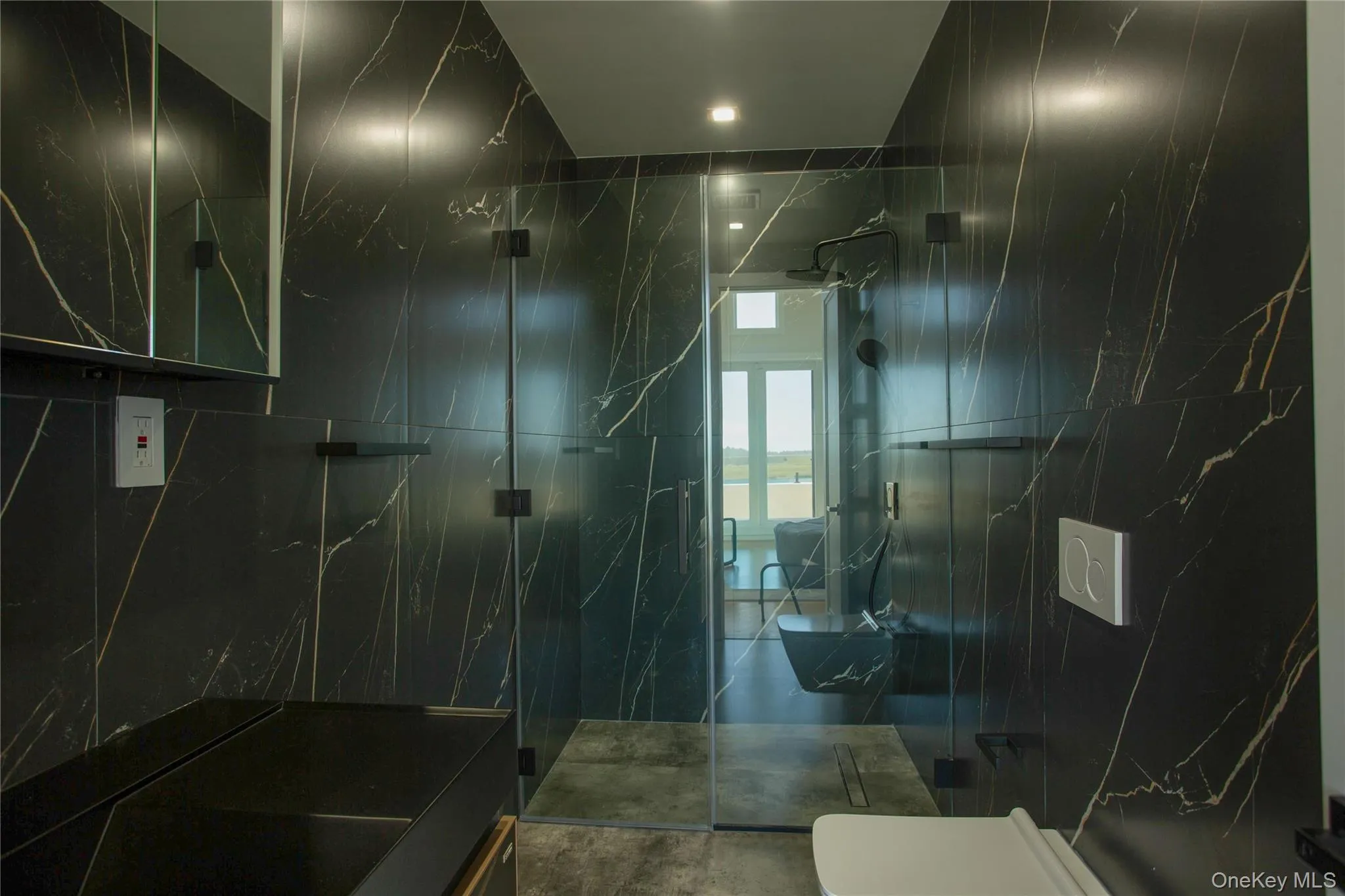 Full bath featuring a marble finish shower and tile walls Full bath featuring a marble finish shower and tile walls