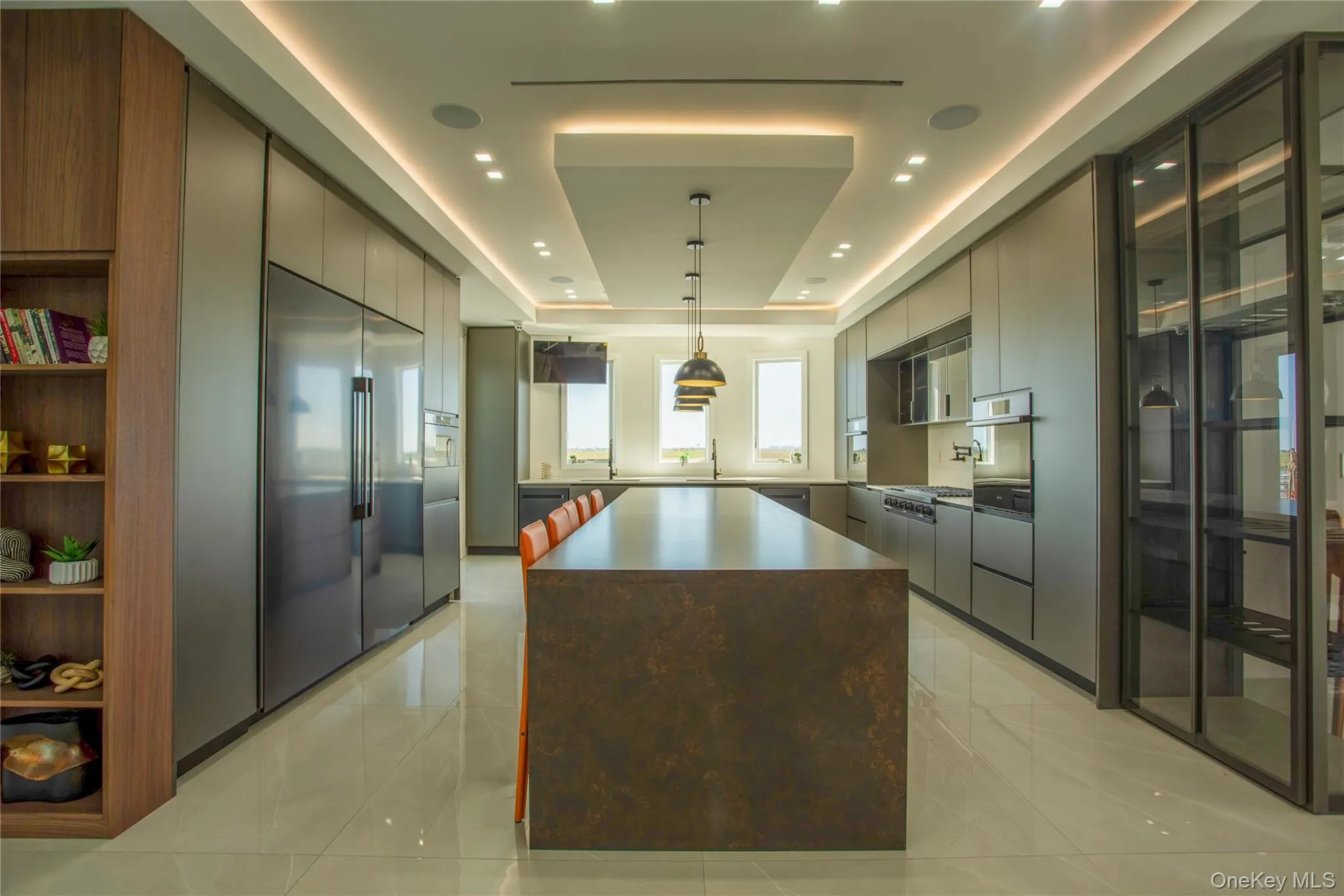 Kitchen with a tray ceiling, modern cabinets, gray cabinets, stainless steel appliances, and a center island Kitchen with a tray ceiling, modern cabinets, gray cabinets, stainless steel appliances, and a center island