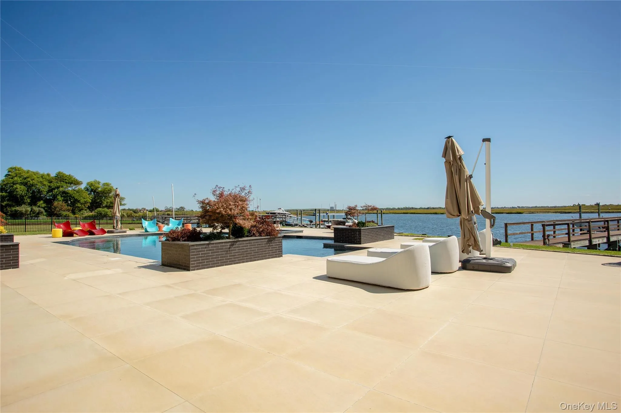 View of patio featuring an outdoor pool and a water view View of patio featuring an outdoor pool and a water view