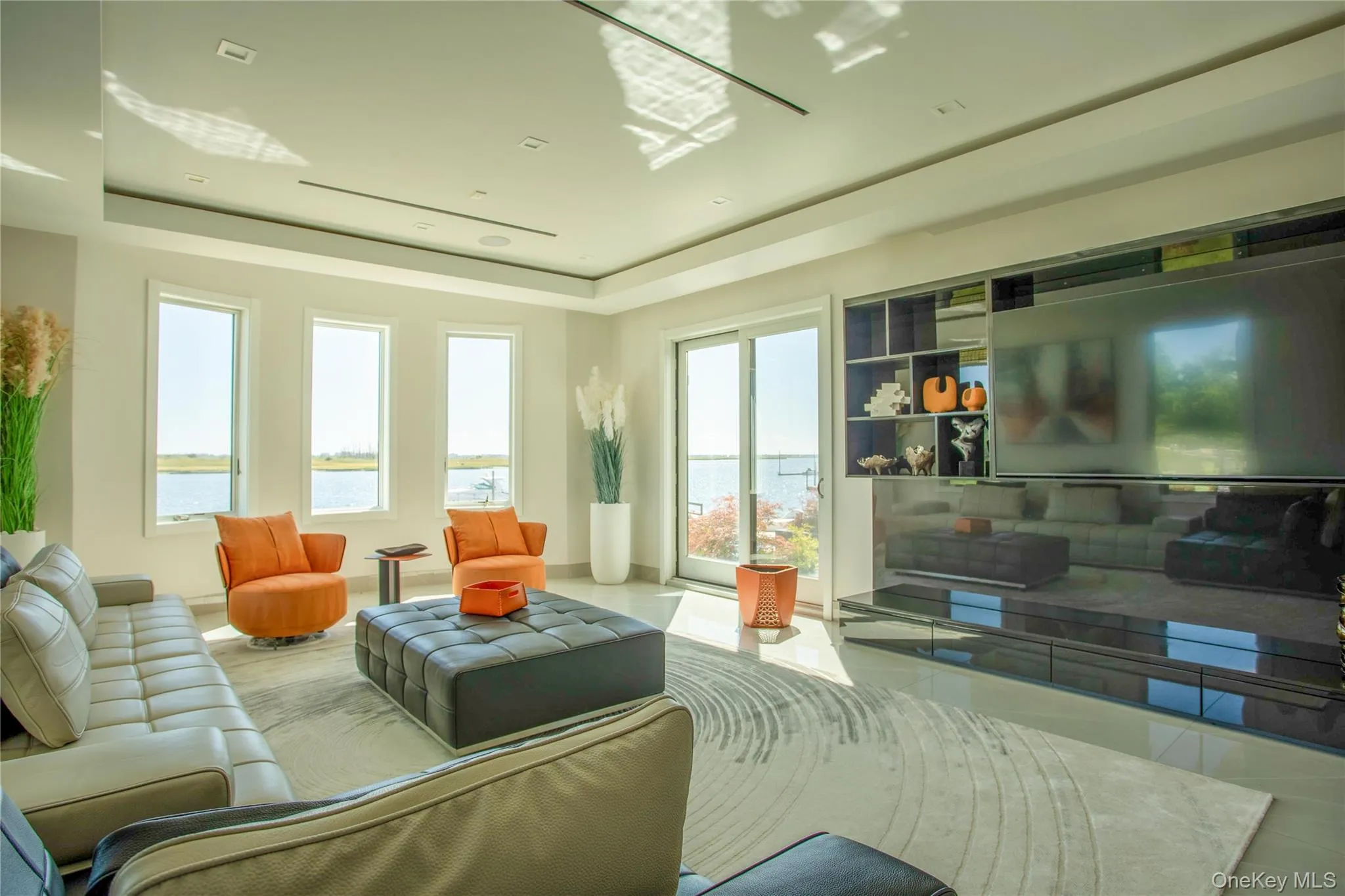 Tiled living room featuring a tray ceiling and baseboards Tiled living room featuring a tray ceiling and baseboards