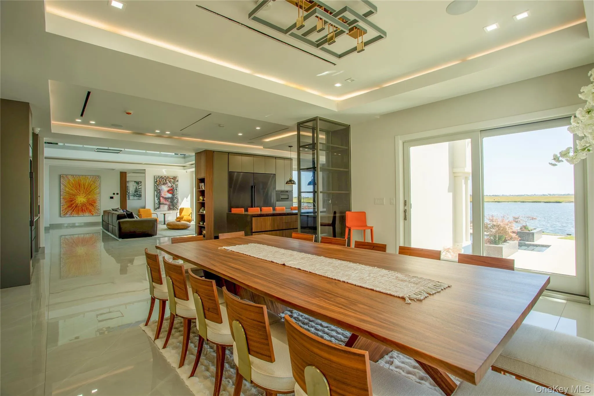 Dining space with a tray ceiling, a water view, and recessed lighting Dining space with a tray ceiling, a water view, and recessed lighting