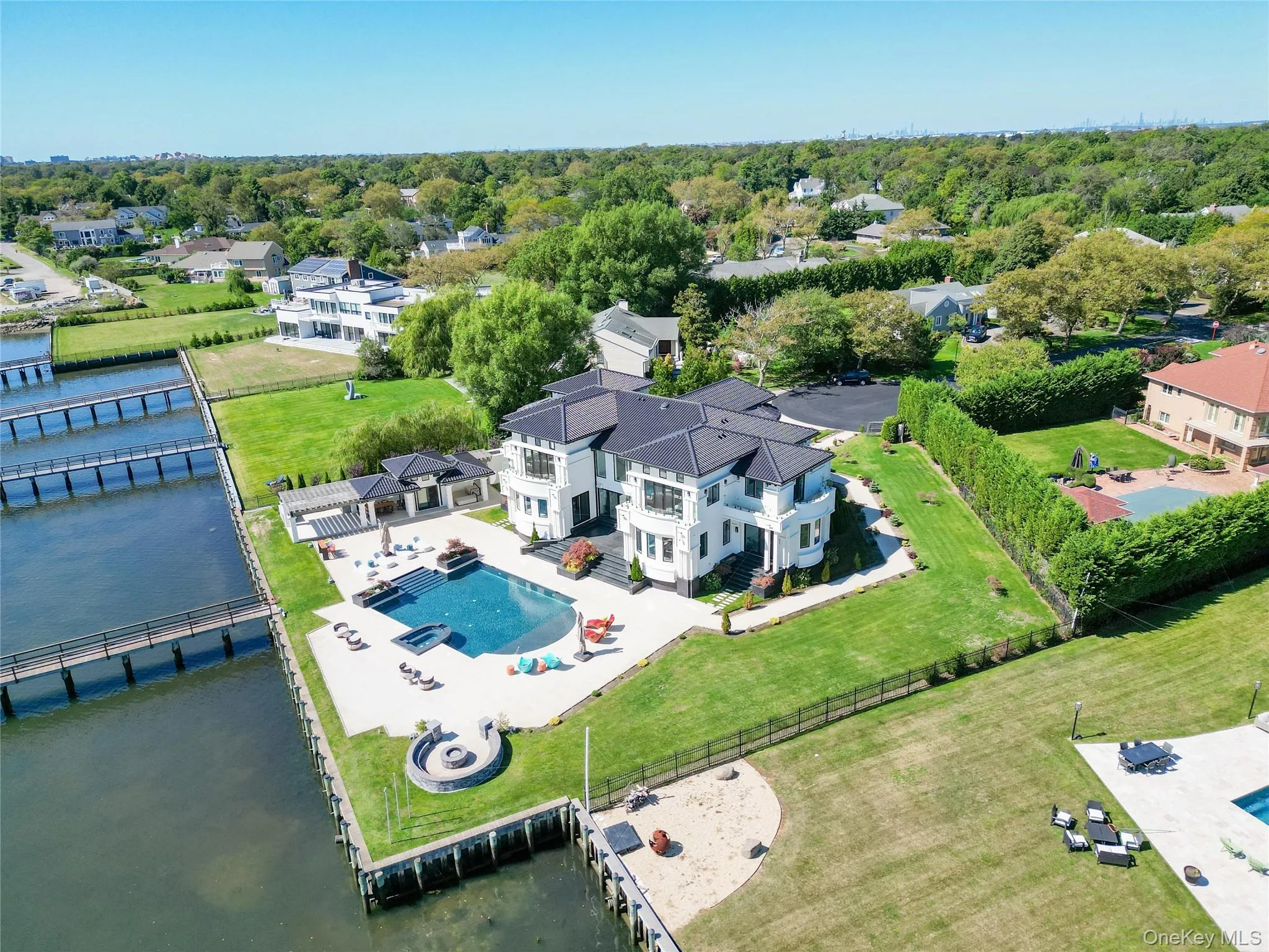 Aerial view of residential area featuring a pool and a nearby body of water Aerial view of residential area featuring a pool and a nearby body of water