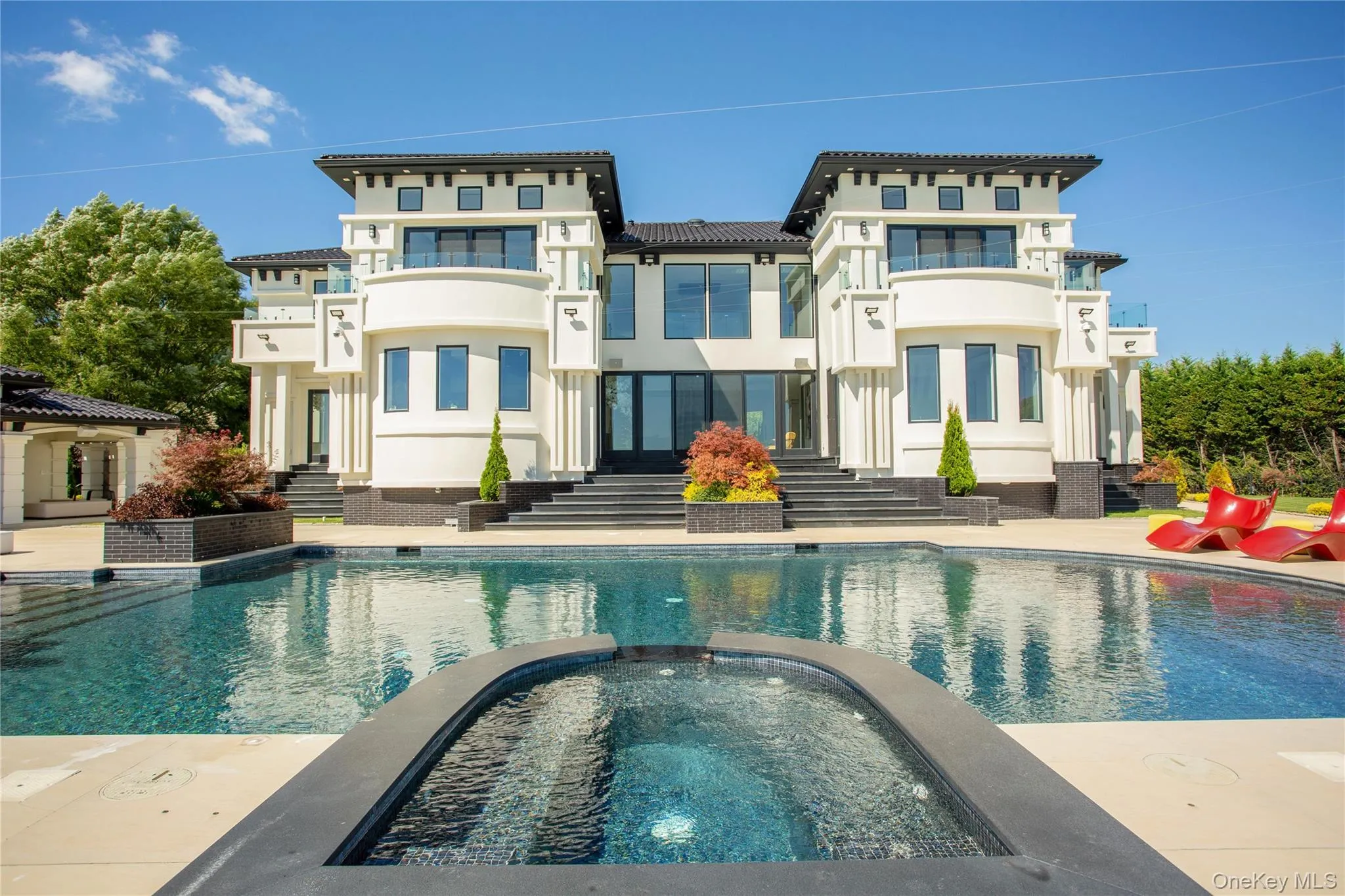 Back of house with a pool with connected hot tub, a patio, and stucco siding Back of house with a pool with connected hot tub, a patio, and stucco siding