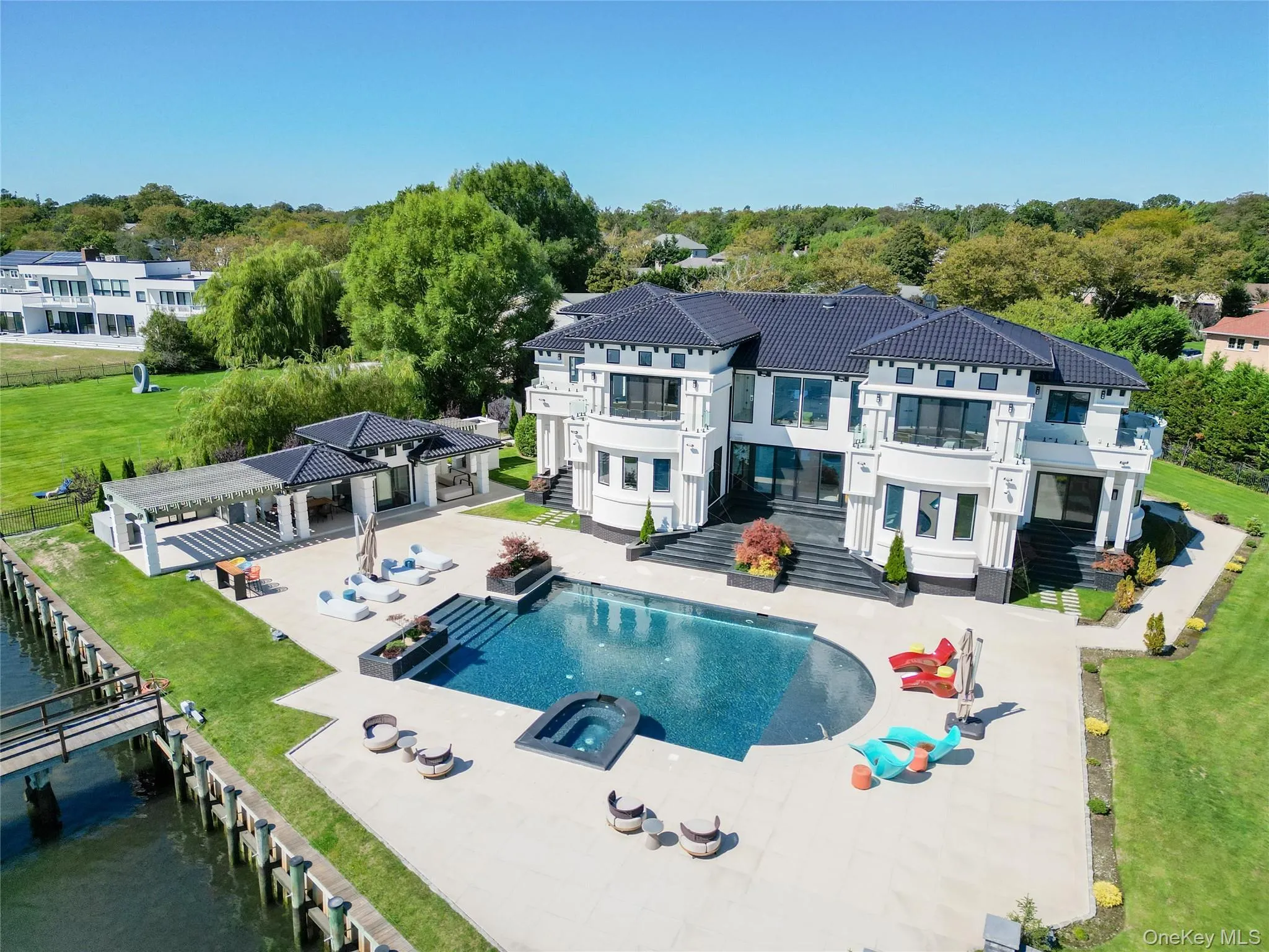 Rear view of house featuring a patio area, a fenced backyard, a balcony, and a pool with connected hot tub Rear view of house featuring a patio area, a fenced backyard, a balcony, and a pool with connected hot tub