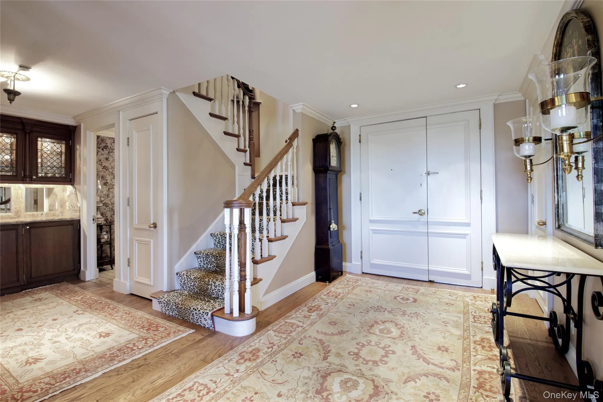 Foyer entrance with stairs, light wood-type flooring, crown molding, and recessed lighting Foyer entrance with stairs, light wood-type flooring, crown molding, and recessed lighting