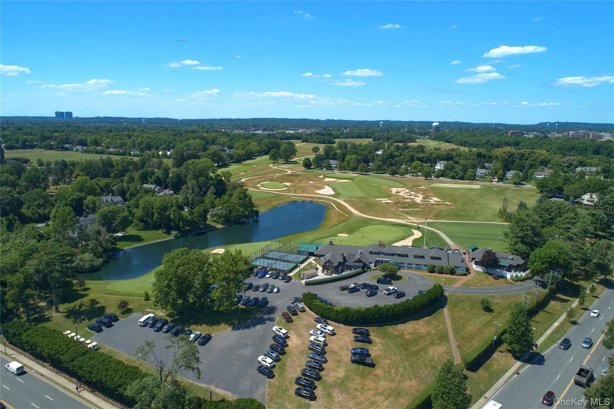 Aerial view of property and surrounding area with a golf course and a large body of water Aerial view of property and surrounding area with a golf course and a large body of water