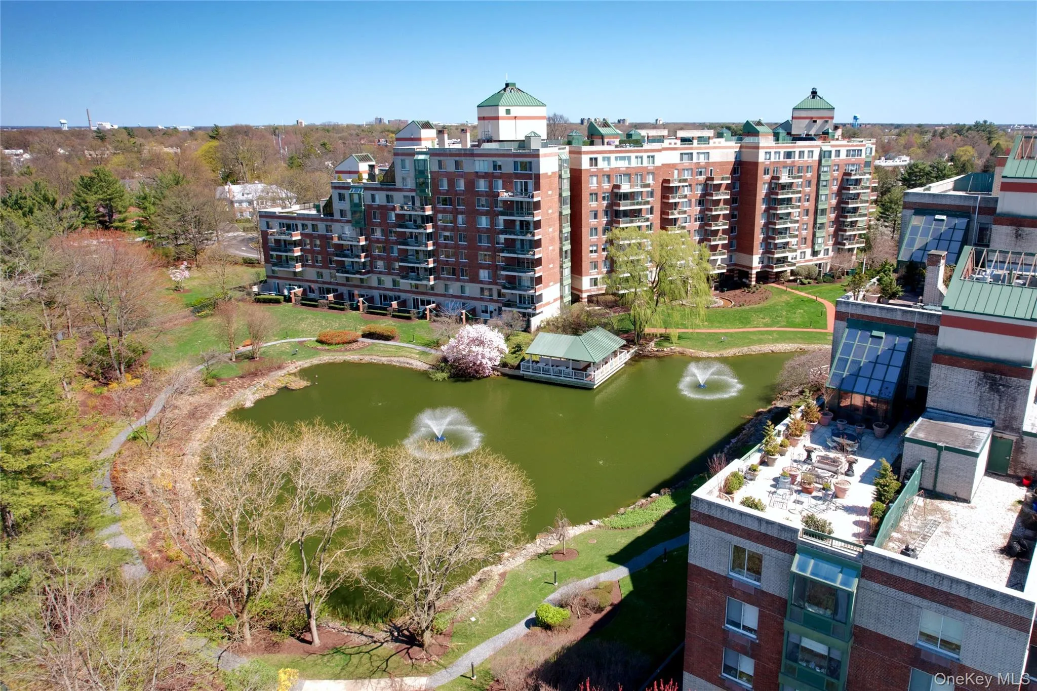 Drone / aerial view of apartment complex and a nearby body of water Drone / aerial view of apartment complex and a nearby body of water