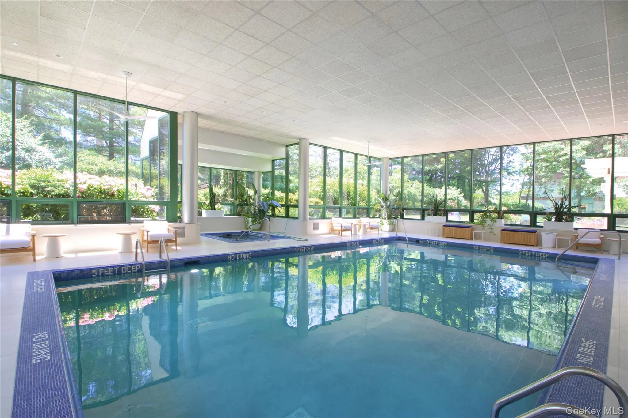 Indoor community pool with a sunroom and glass enclosure Indoor community pool with a sunroom and glass enclosure