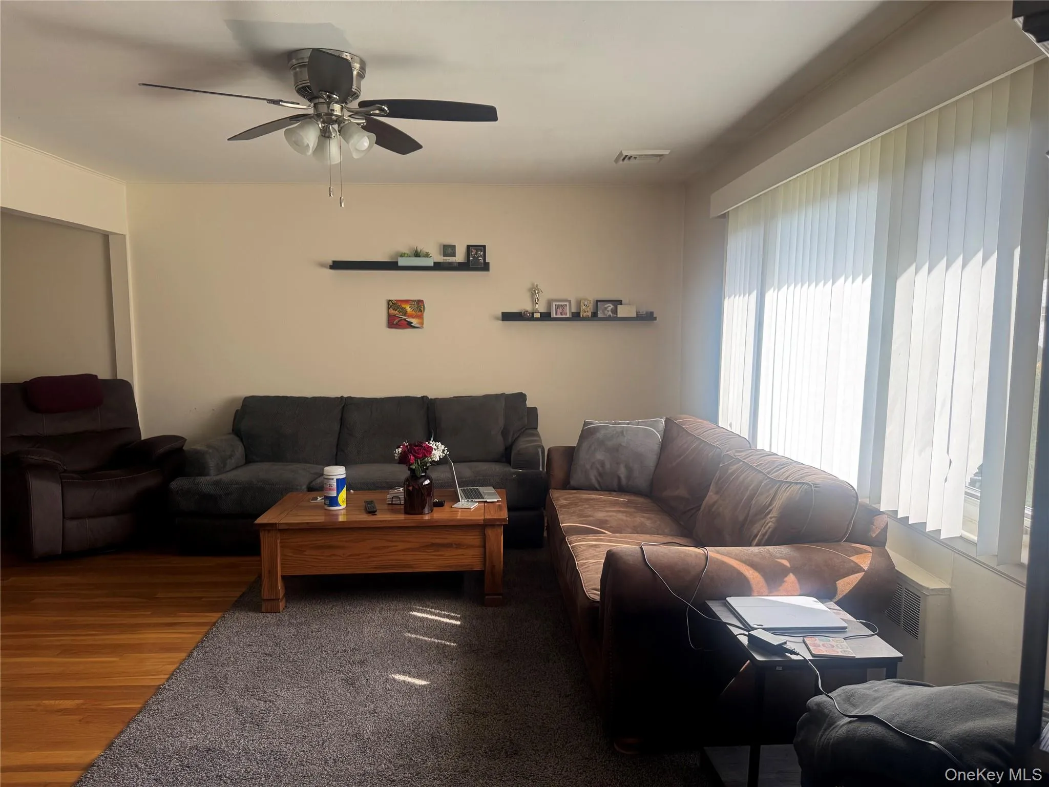 Living area featuring wood finished floors and a ceiling fan Living area featuring wood finished floors and a ceiling fan