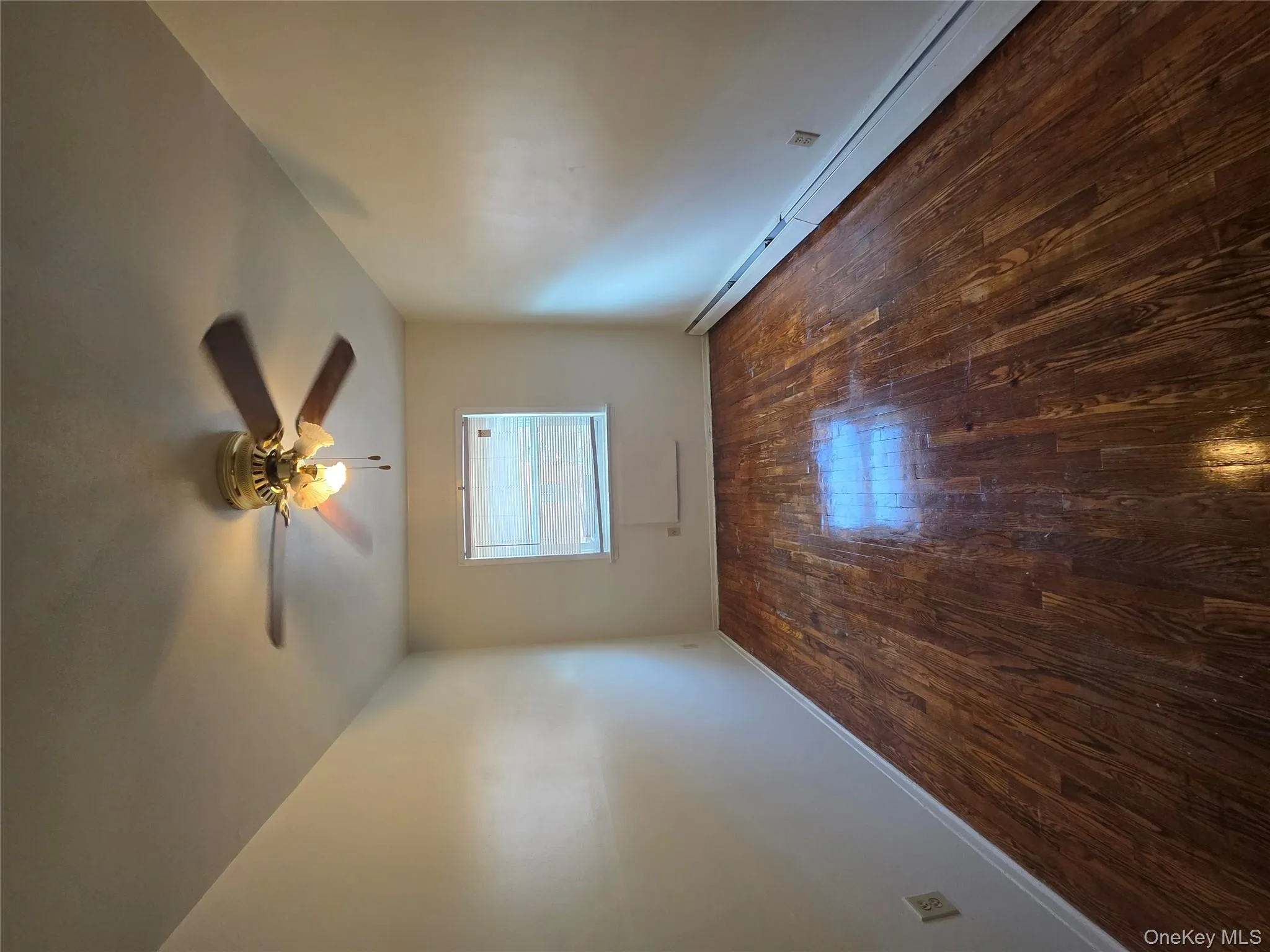 Unfurnished room with a baseboard radiator, dark wood-style flooring, and a ceiling fan Unfurnished room with a baseboard radiator, dark wood-style flooring, and a ceiling fan