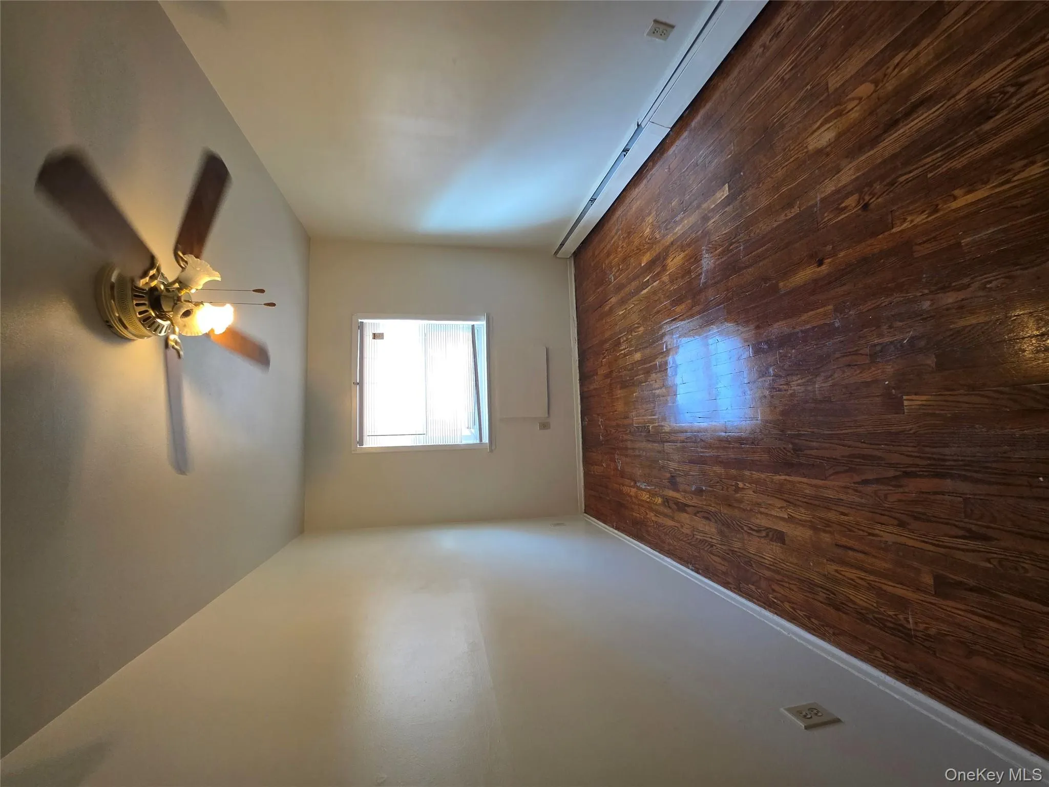Unfurnished room featuring a baseboard radiator, dark wood finished floors, and ceiling fan Unfurnished room featuring a baseboard radiator, dark wood finished floors, and ceiling fan