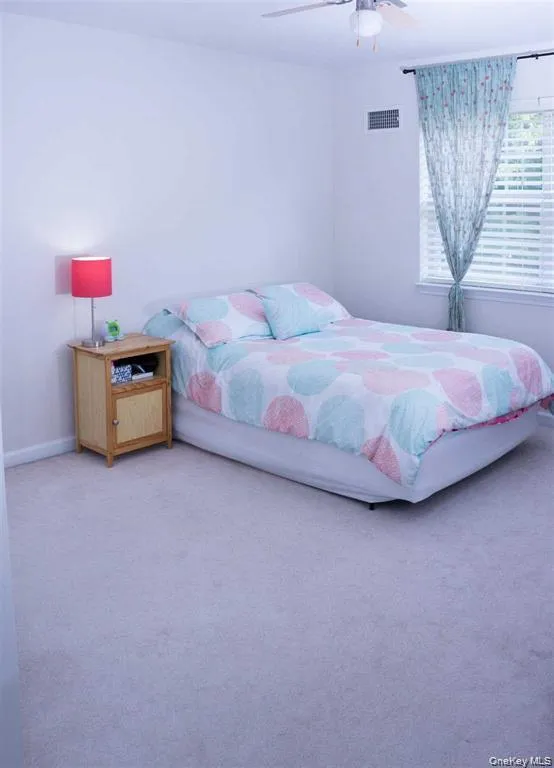 Carpeted bedroom featuring ceiling fan and baseboards Carpeted bedroom featuring ceiling fan and baseboards