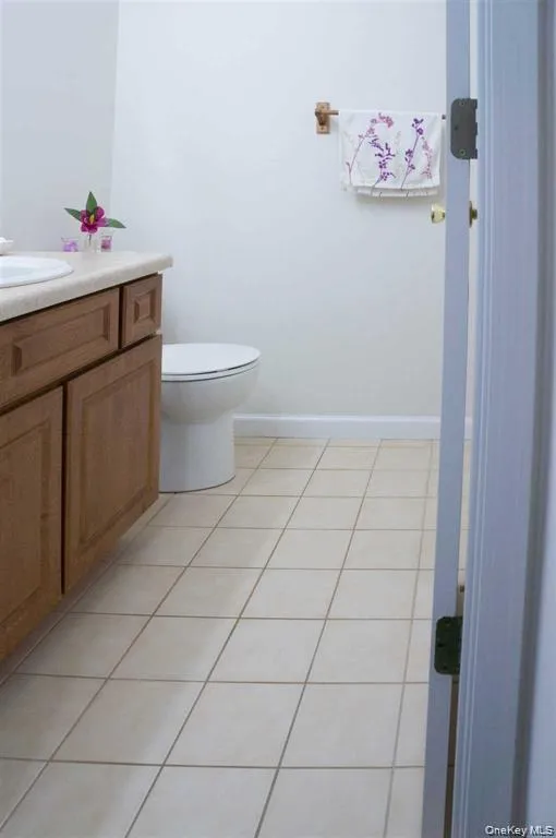 Half bath with light tile patterned floors and vanity Half bath with light tile patterned floors and vanity