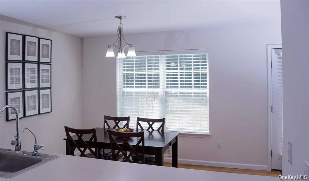 Dining space with wood finished floors and a chandelier Dining space with wood finished floors and a chandelier