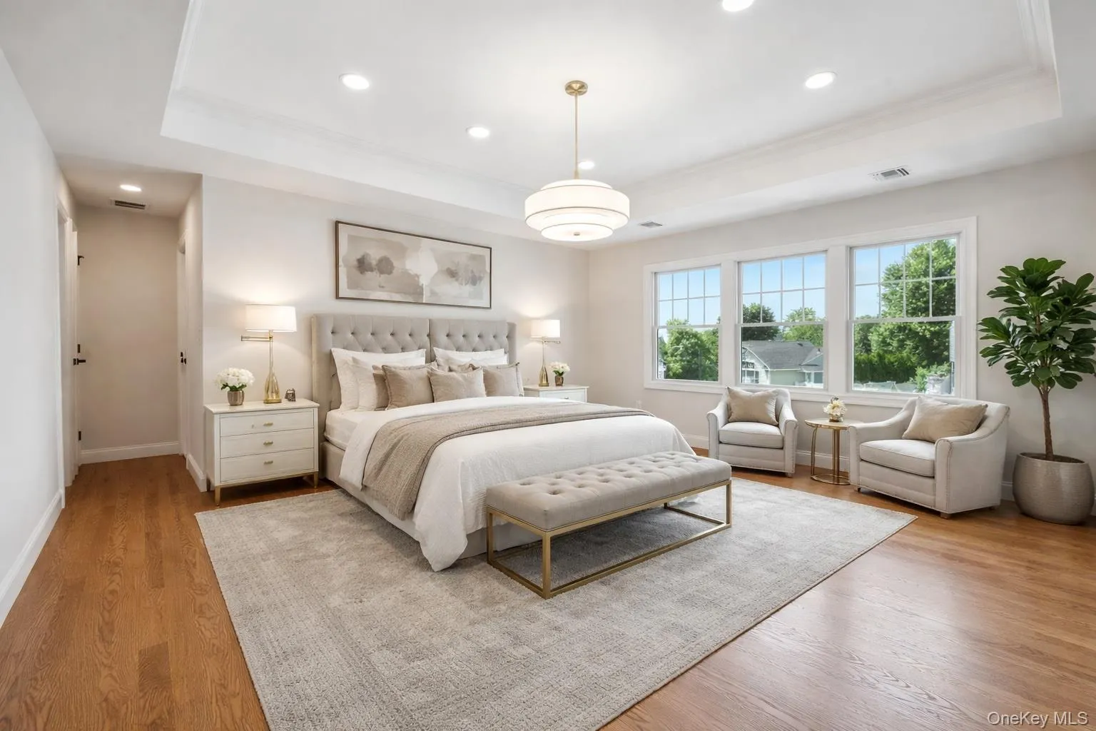 Bedroom with a tray ceiling, light wood-style floors, recessed lighting, and ornamental molding Bedroom with a tray ceiling, light wood-style floors, recessed lighting, and ornamental molding