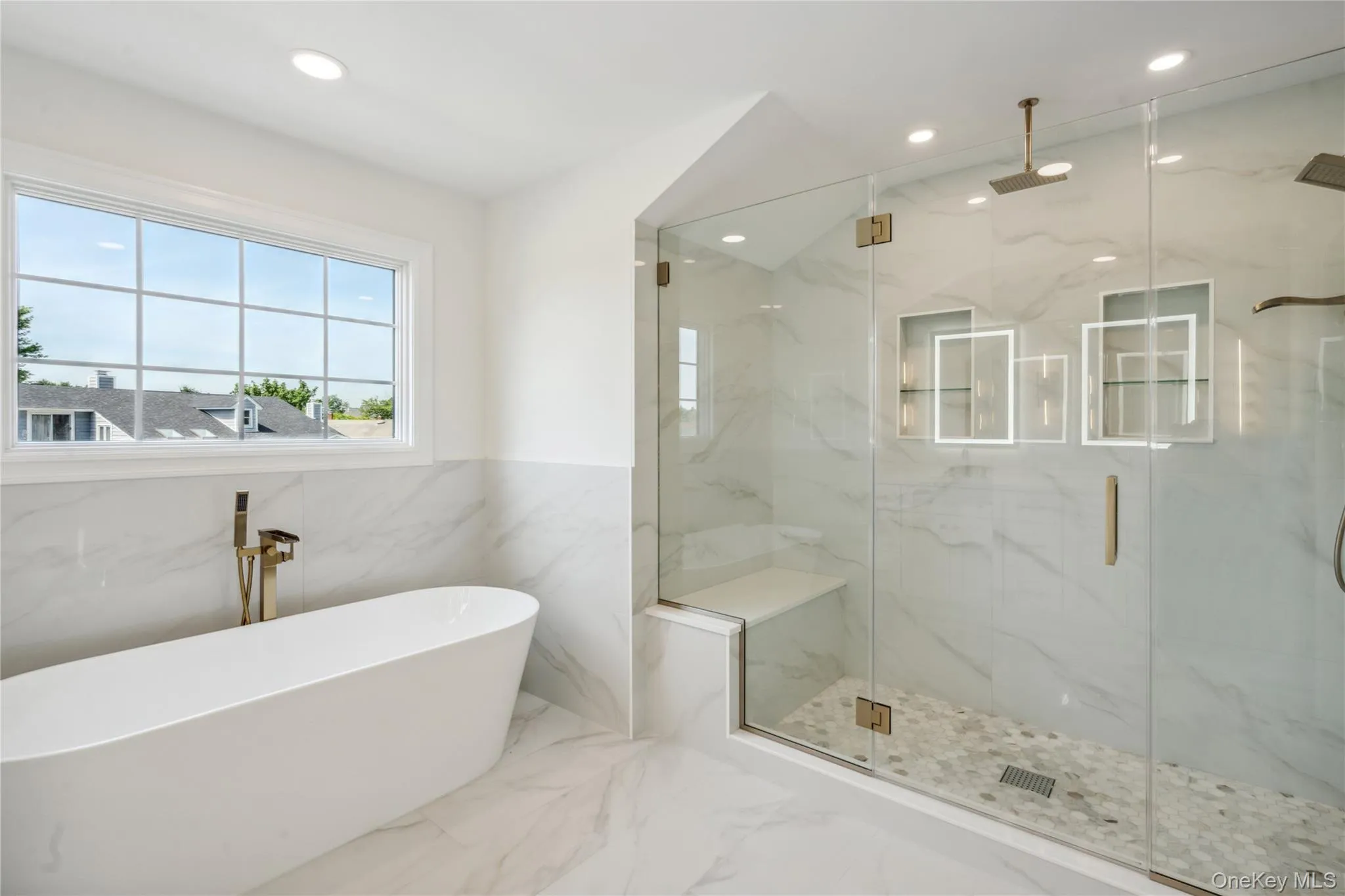Bathroom with marble tiled floors, a soaking tub, recessed lighting, a marble finish shower, and tile walls Bathroom with marble tiled floors, a soaking tub, recessed lighting, a marble finish shower, and tile walls