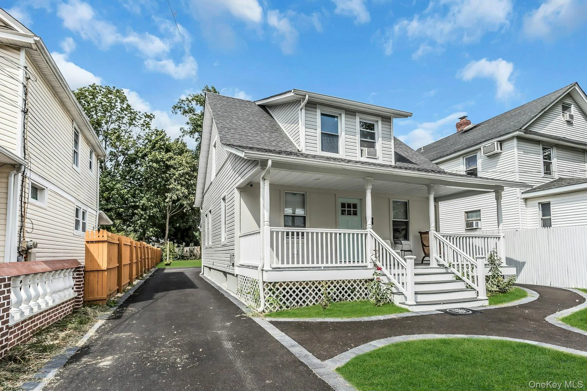 Bungalow featuring covered porch, roof with shingles, and asphalt driveway Bungalow featuring covered porch, roof with shingles, and asphalt driveway