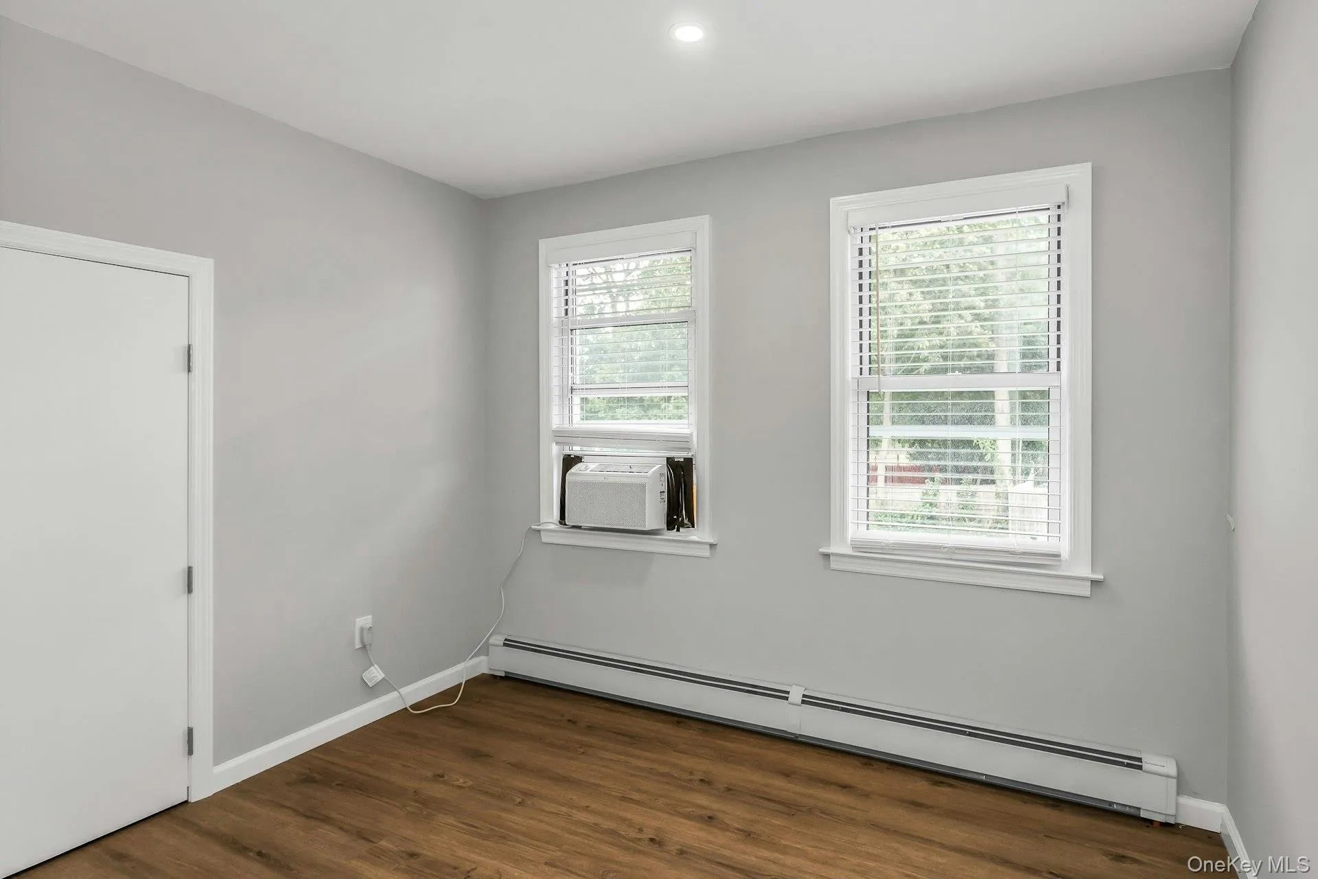 Unfurnished room featuring a baseboard heating unit, dark wood finished floors, and recessed lighting Unfurnished room featuring a baseboard heating unit, dark wood finished floors, and recessed lighting