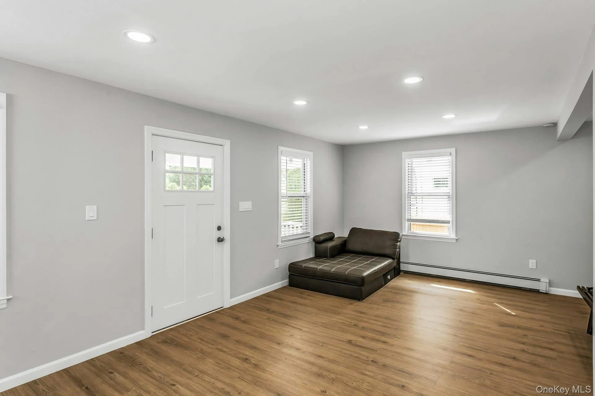 Foyer entrance featuring a baseboard heating unit, recessed lighting, plenty of natural light, and wood finished floors Foyer entrance featuring a baseboard heating unit, recessed lighting, plenty of natural light, and wood finished floors