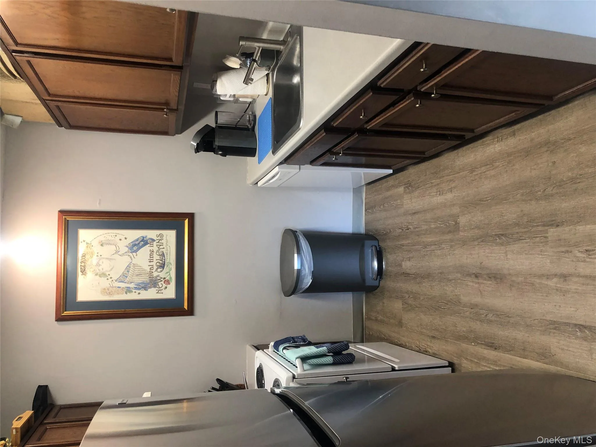 Kitchen with dark brown cabinetry, refrigerator, range, light countertops, and light wood-style floors Kitchen with dark brown cabinetry, refrigerator, range, light countertops, and light wood-style floors