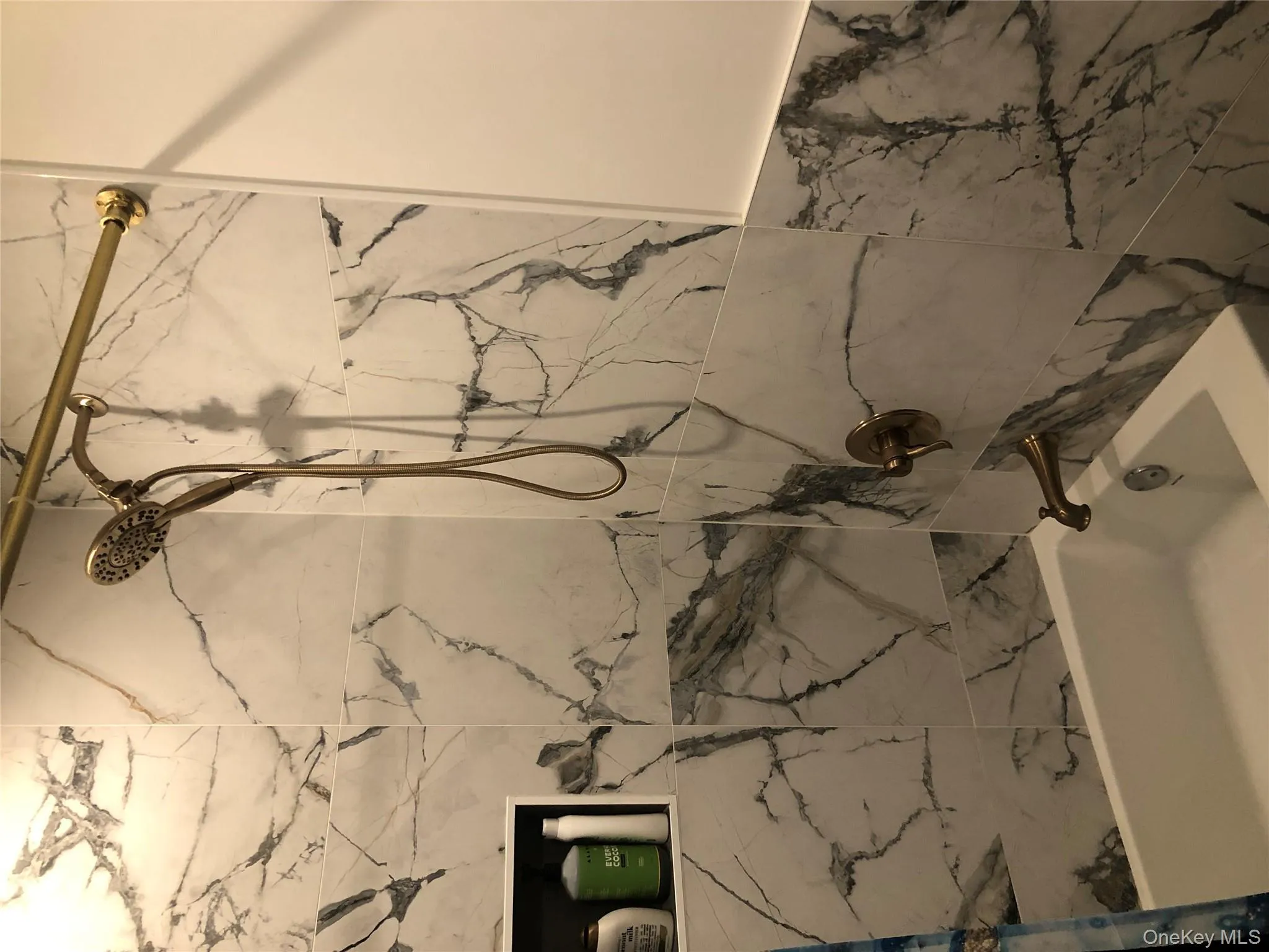 Full bath with a combined bath / shower with marble appearance Full bath with a combined bath / shower with marble appearance