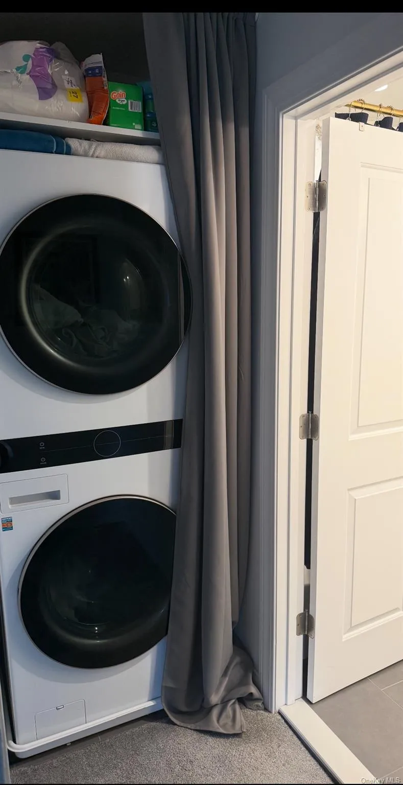 Laundry room with stacked washing machine and dryer Laundry room with stacked washing machine and dryer