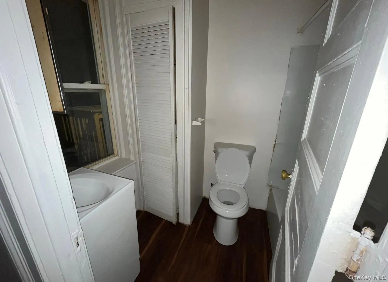 Bathroom with dark wood-style floors, vanity, and washer / dryer Bathroom with dark wood-style floors, vanity, and washer / dryer
