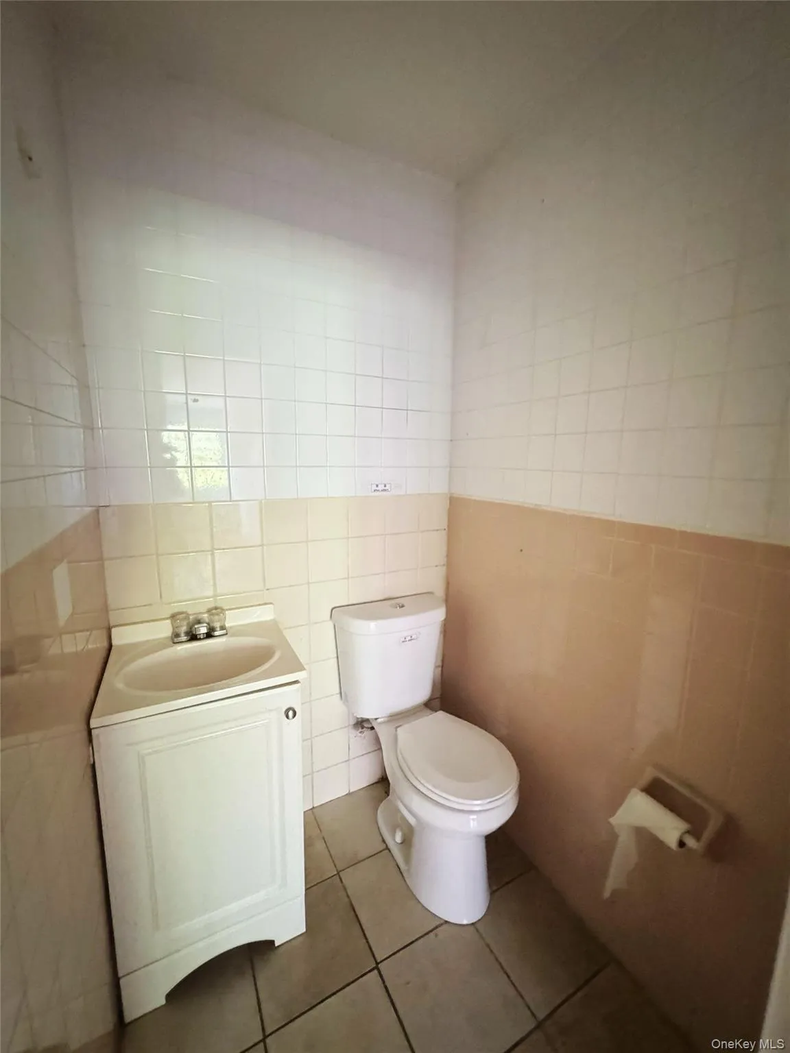 Half bathroom featuring tile walls, vanity, and tile patterned floors Half bathroom featuring tile walls, vanity, and tile patterned floors