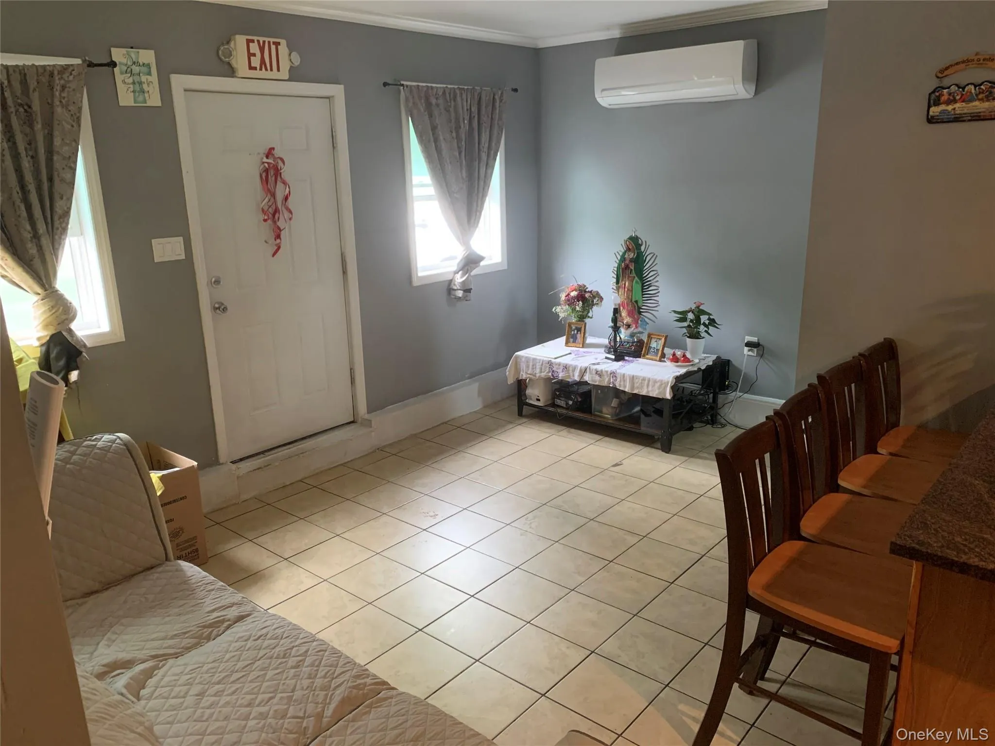 Foyer entrance with a wall mounted air conditioner, light tile patterned floors, and ornamental molding Foyer entrance with a wall mounted air conditioner, light tile patterned floors, and ornamental molding