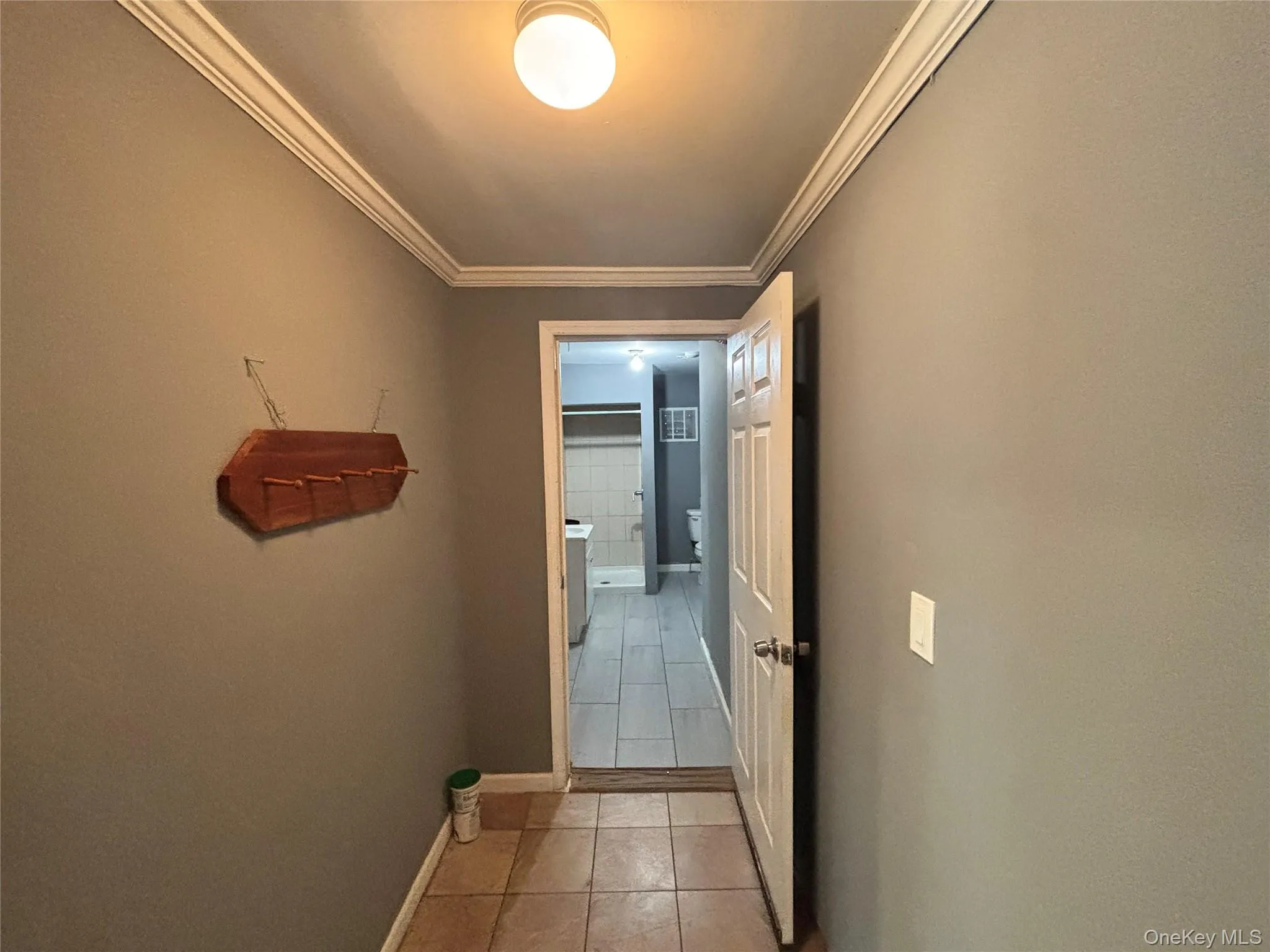 Corridor with ornamental molding and light tile patterned floors Corridor with ornamental molding and light tile patterned floors