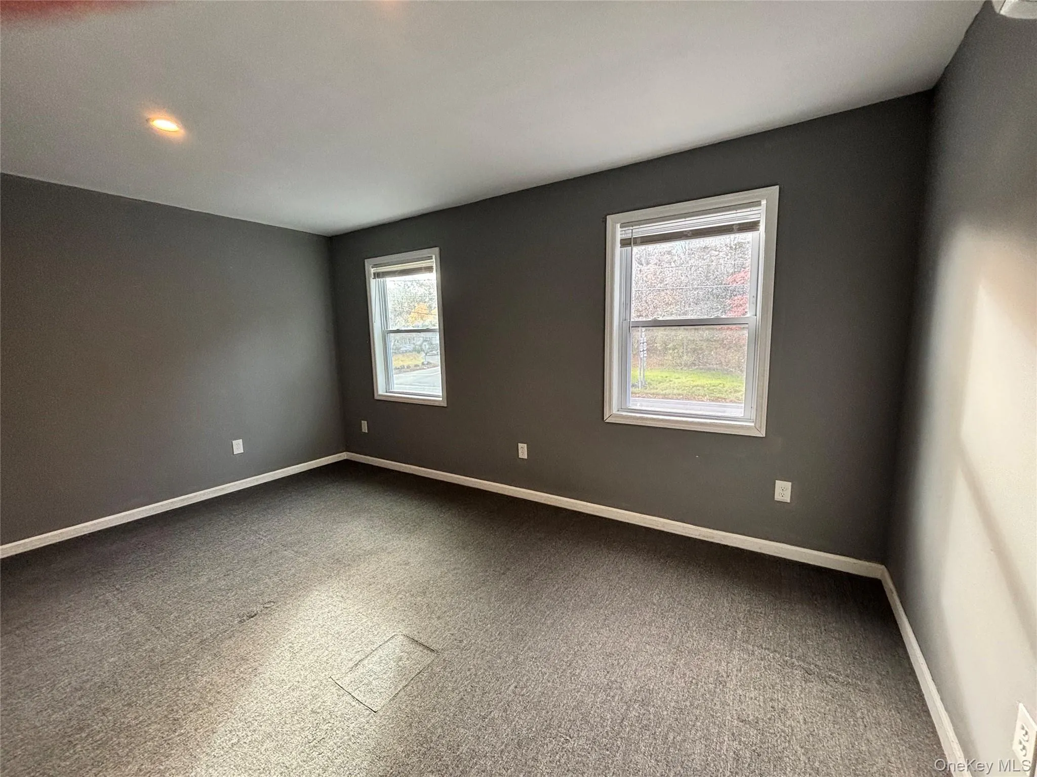 Carpeted empty room featuring baseboards Carpeted empty room featuring baseboards