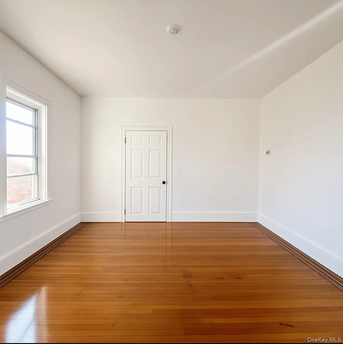 Empty room featuring baseboards and wood-type flooring Empty room featuring baseboards and wood-type flooring