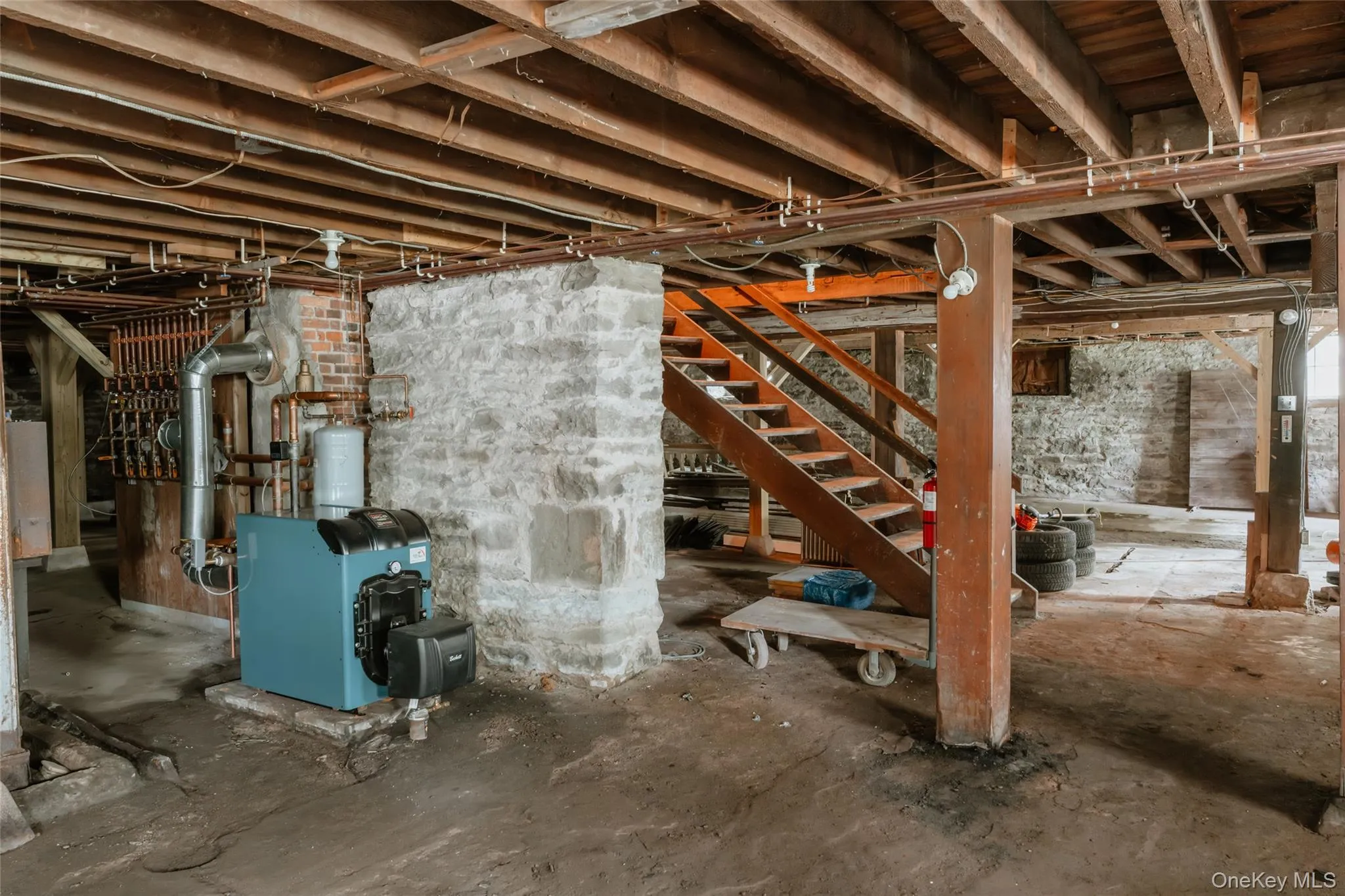 Unfinished basement featuring a heating unit and stairs Unfinished basement featuring a heating unit and stairs