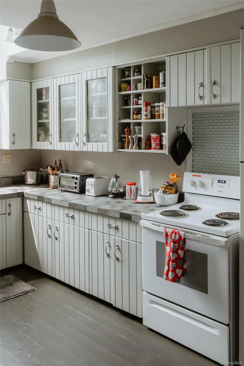 Kitchen featuring white range with electric cooktop, white cabinets, open shelves, and tile counters Kitchen featuring white range with electric cooktop, white cabinets, open shelves, and tile counters