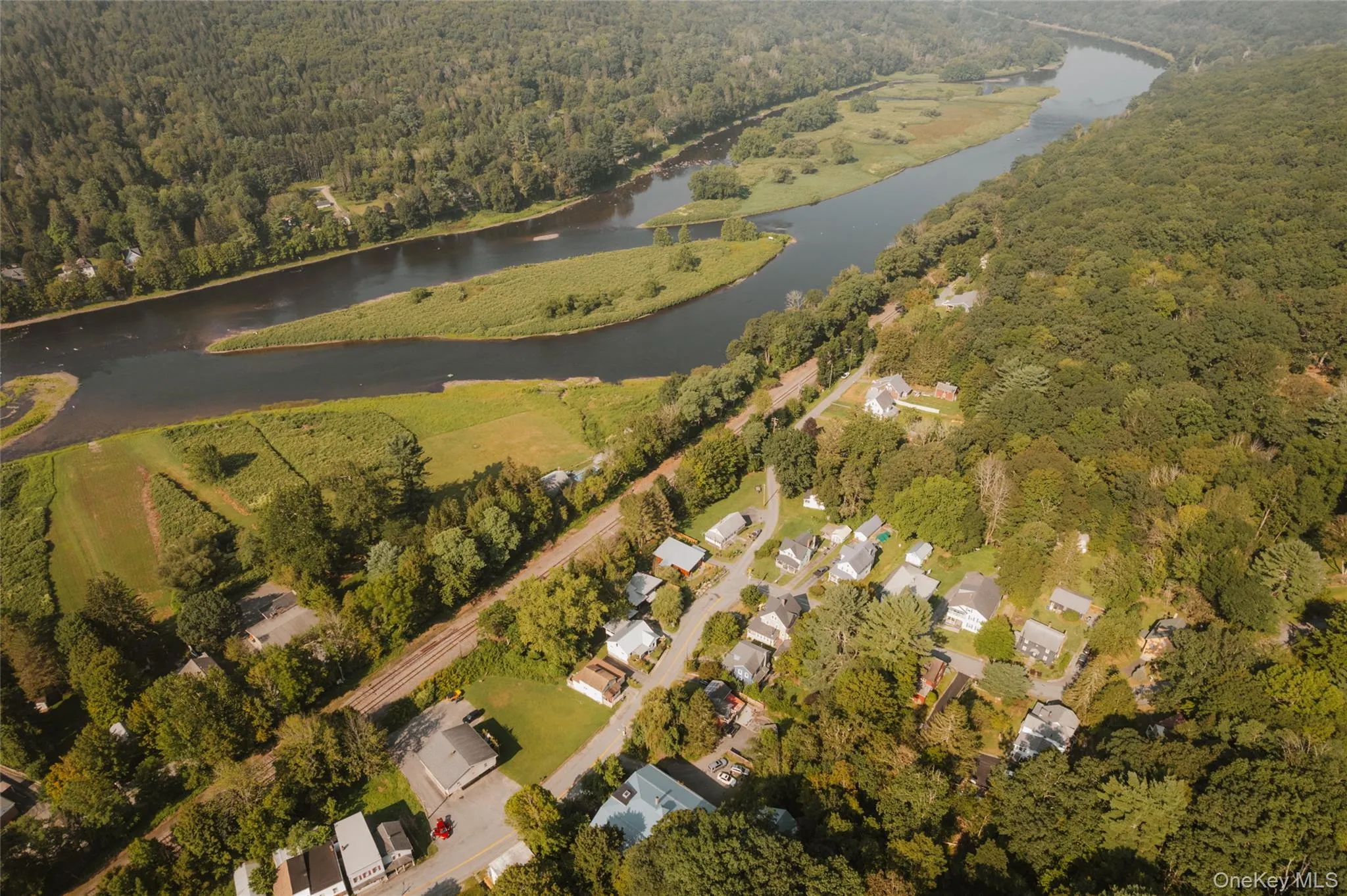 Aerial overview of property's location featuring a heavily wooded area and a nearby body of water Aerial overview of property's location featuring a heavily wooded area and a nearby body of water