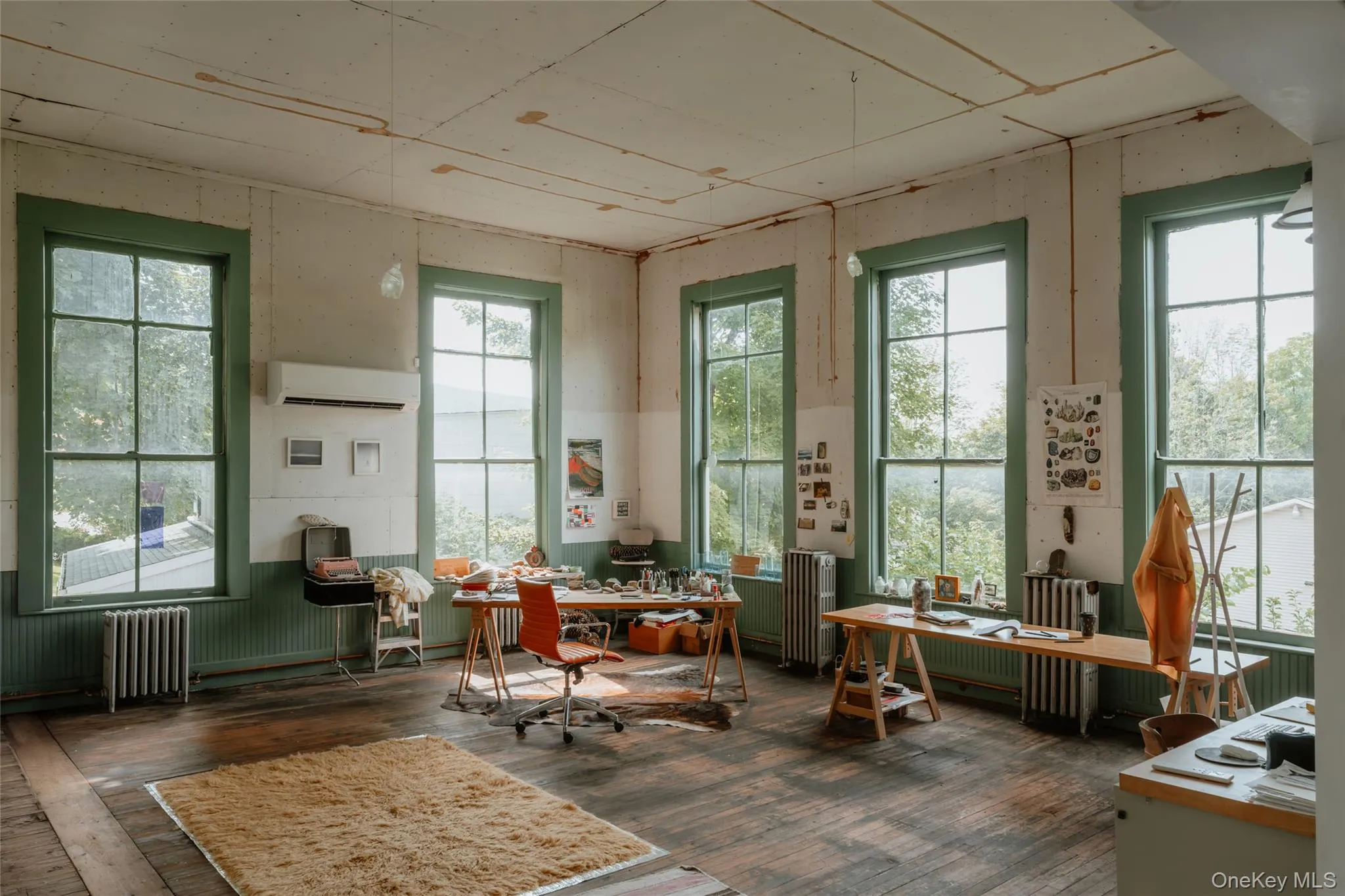 Office area with radiator heating unit, dark wood-style floors, plenty of natural light, and wainscoting Office area with radiator heating unit, dark wood-style floors, plenty of natural light, and wainscoting