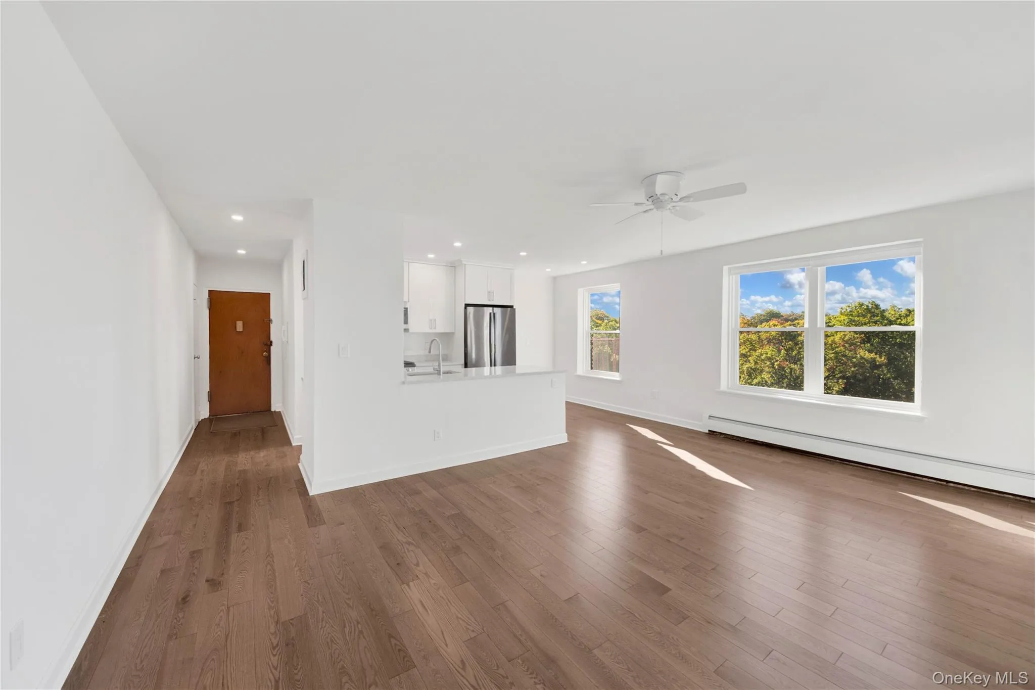 Unfurnished living room with dark wood-type flooring, a baseboard radiator, recessed lighting, and ceiling fan Unfurnished living room with dark wood-type flooring, a baseboard radiator, recessed lighting, and ceiling fan