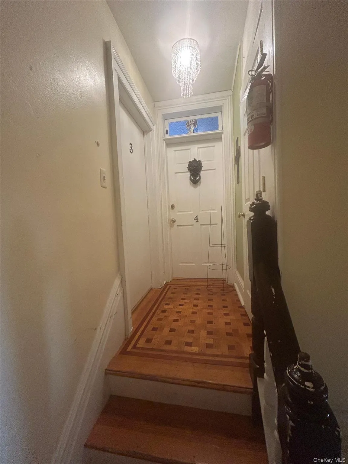 Doorway to outside featuring a chandelier and wood finished floors Doorway to outside featuring a chandelier and wood finished floors