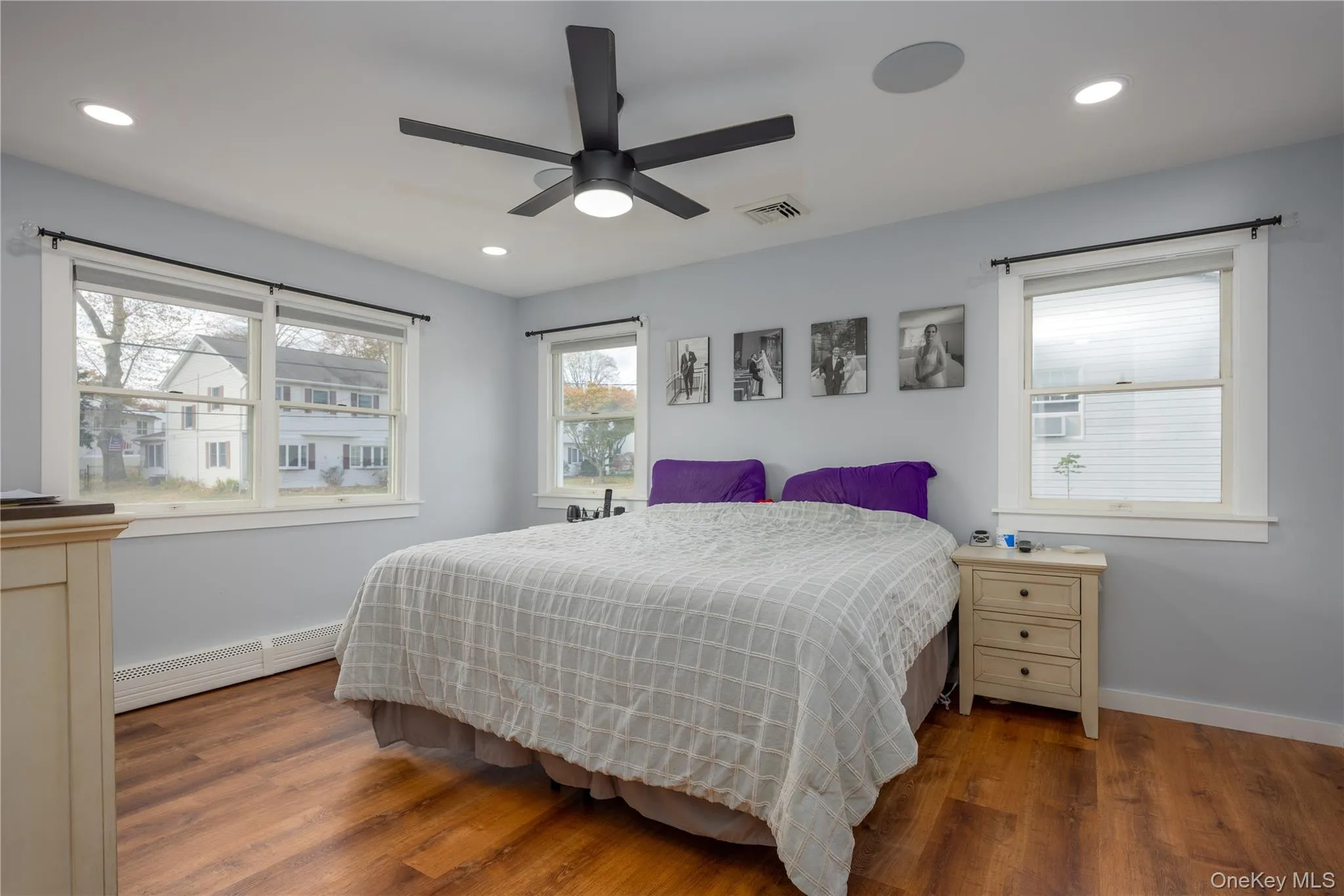 Bedroom with wood finished floors, a baseboard radiator, ceiling fan, and recessed lighting Bedroom with wood finished floors, a baseboard radiator, ceiling fan, and recessed lighting