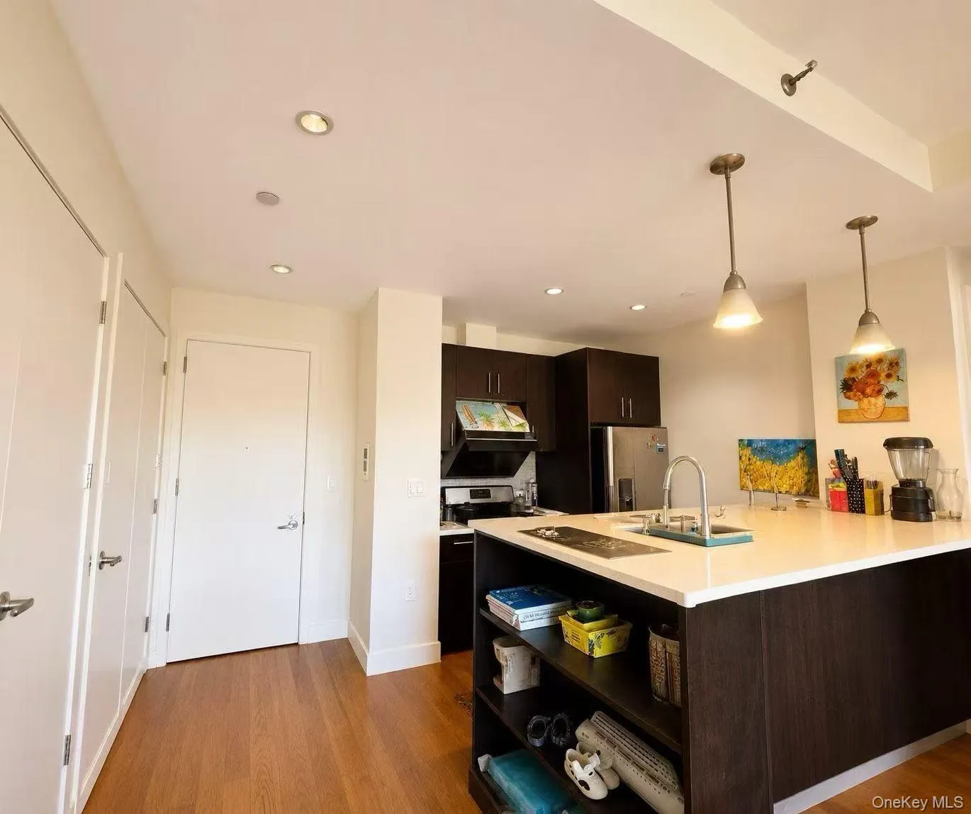 Kitchen featuring hanging light fixtures, dark brown cabinets, dark wood-type flooring, stainless steel appliances, and recessed lighting Kitchen featuring hanging light fixtures, dark brown cabinets, dark wood-type flooring, stainless steel appliances, and recessed lighting