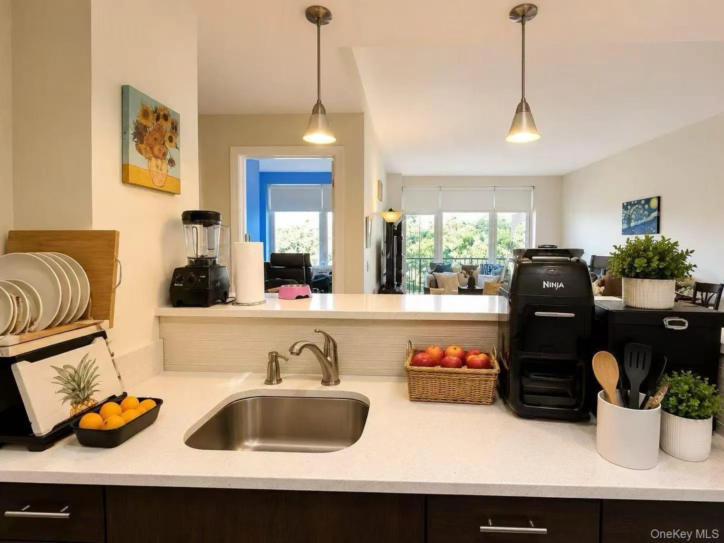 Kitchen featuring hanging light fixtures and light stone counters Kitchen featuring hanging light fixtures and light stone counters