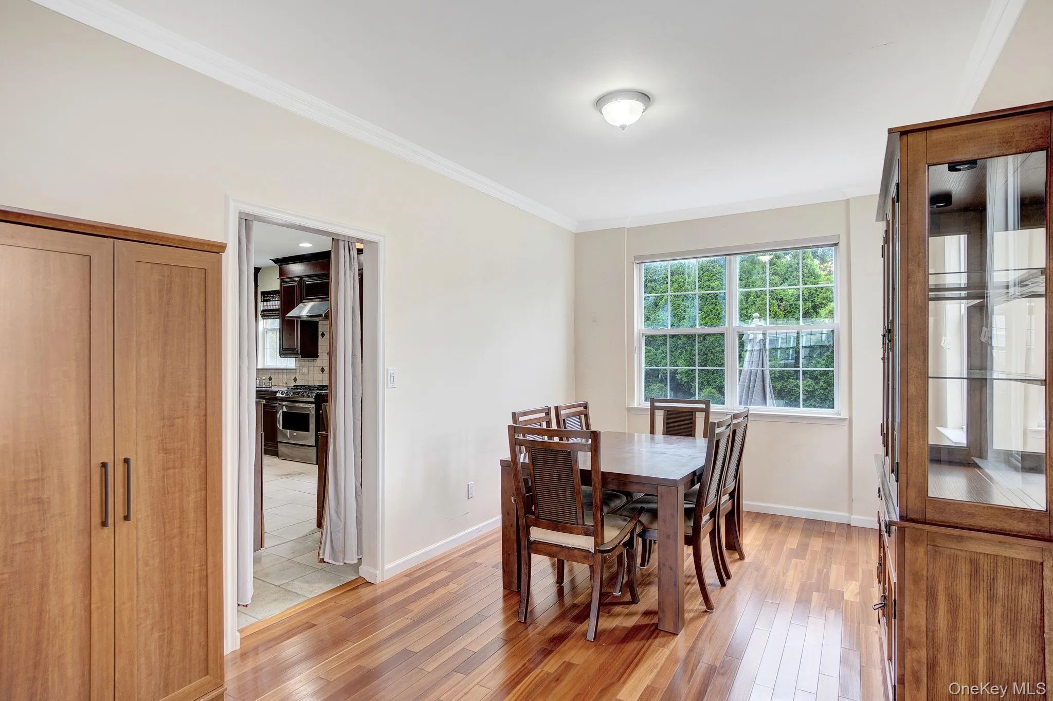 Dining space with ornamental molding and light wood-style flooring Dining space with ornamental molding and light wood-style flooring