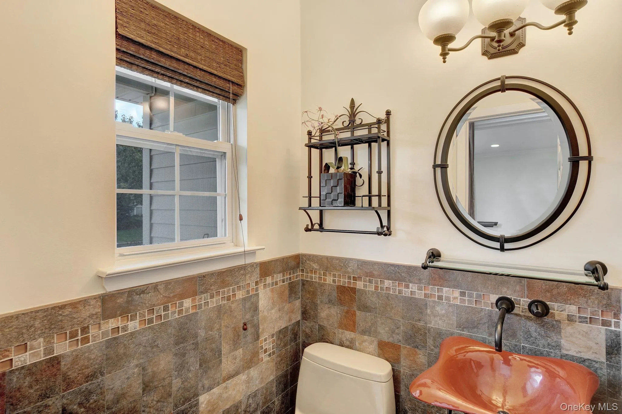 Bathroom featuring tile walls and a wainscoted wall Bathroom featuring tile walls and a wainscoted wall