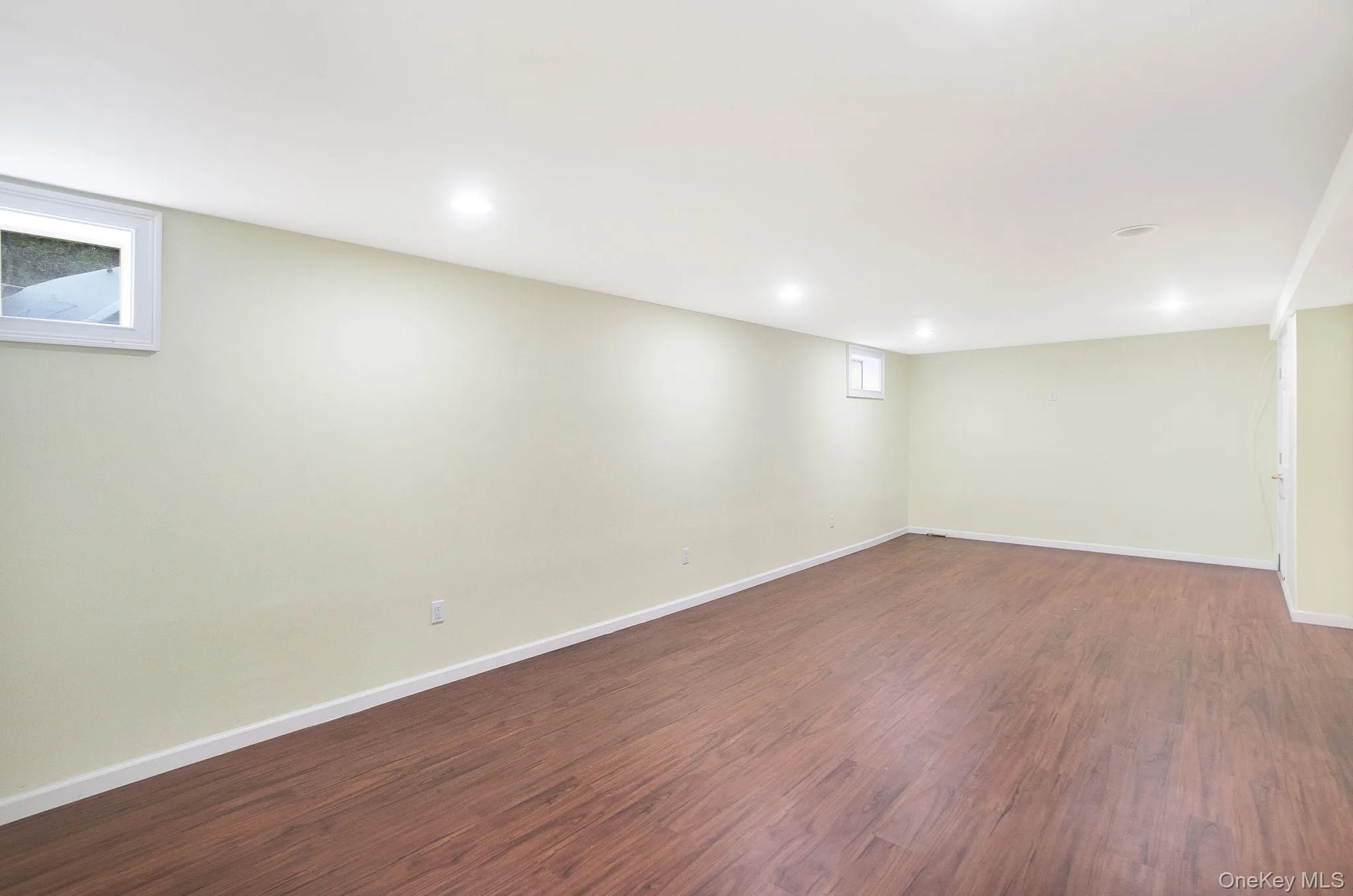Basement with dark wood-type flooring and recessed lighting Basement with dark wood-type flooring and recessed lighting